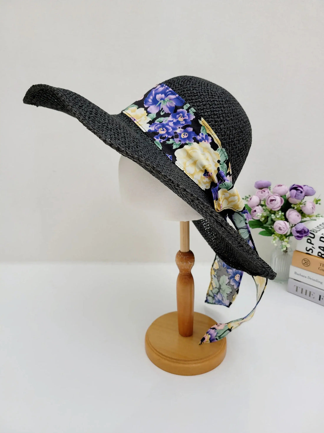 East Hampton black straw sun hat with a vibrant floral ribbon detail and a wide brim for sun protection.