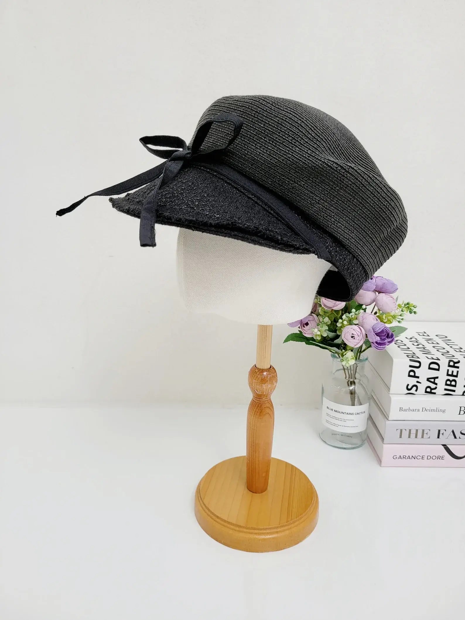 GRACE: Stylish black hat with a ribbon accent, displayed on a mannequin head.