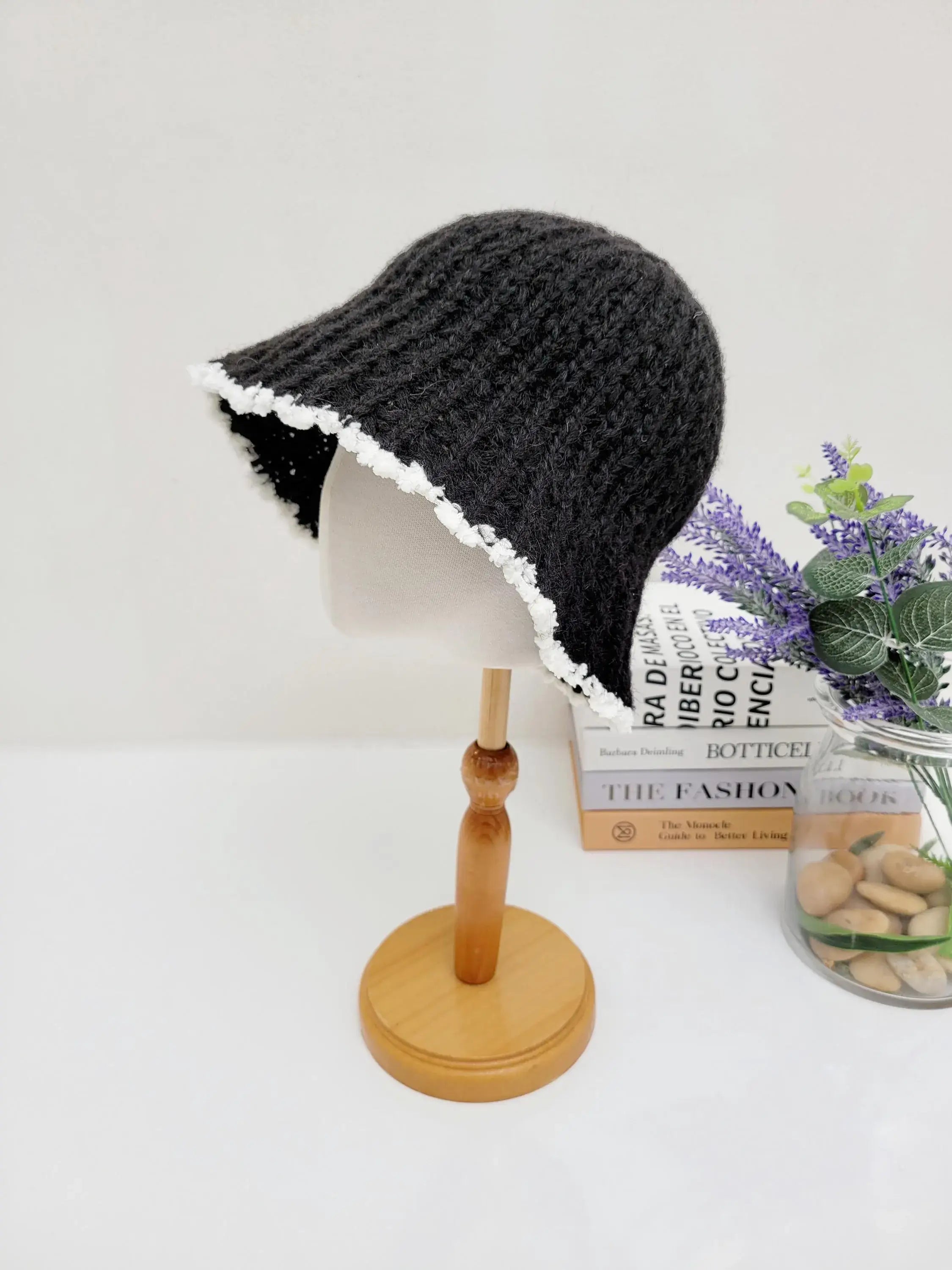 Black vintage knitted beanie with a charming white scalloped edge, displayed on a mannequin head.