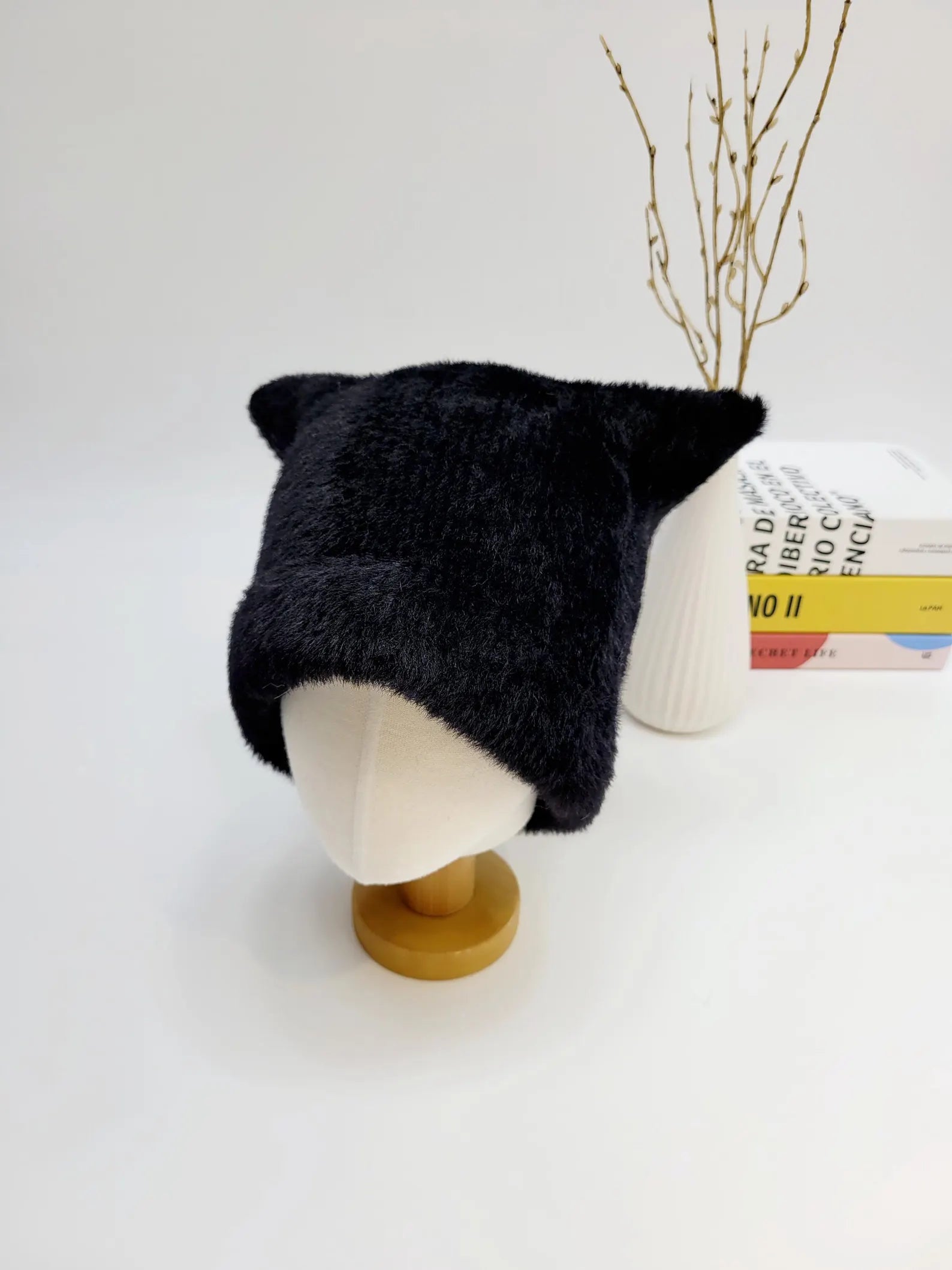 elf in the hat: A soft, black fuzzy winter hat with adorable cat ears, displayed on a mannequin head. A cute and stylish accessory.