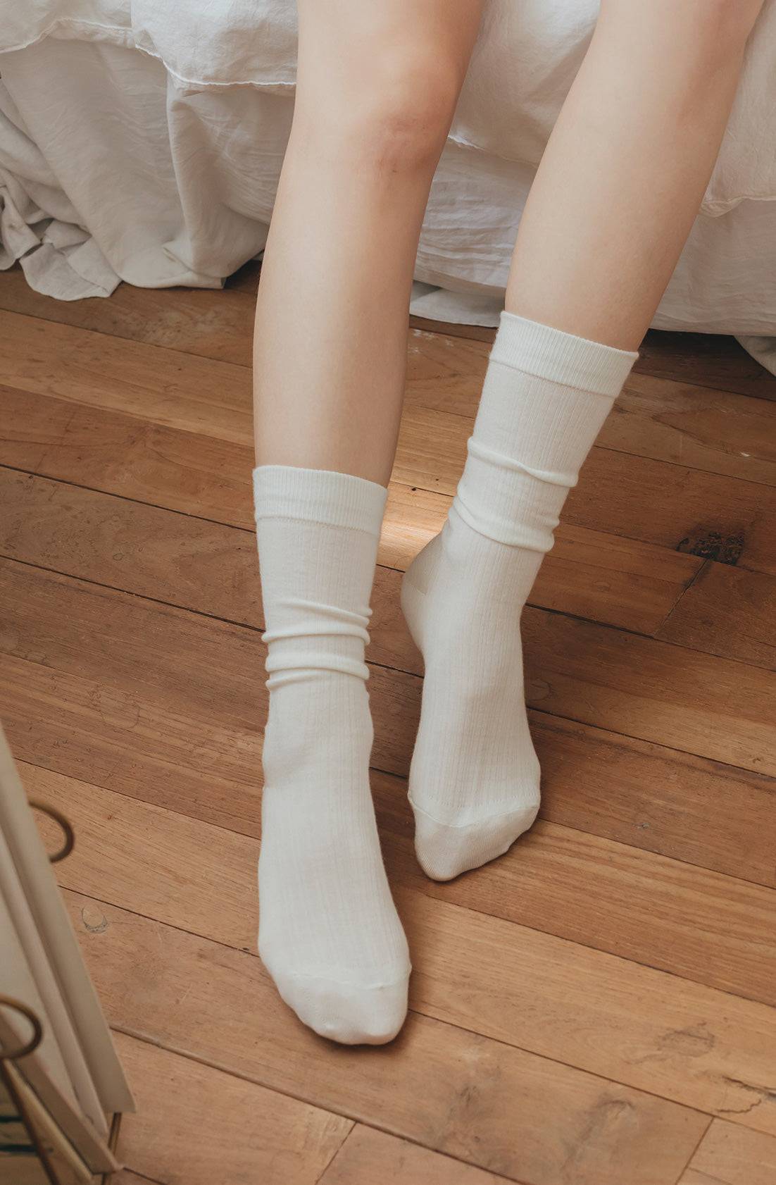 White socks worn on a wooden floor
