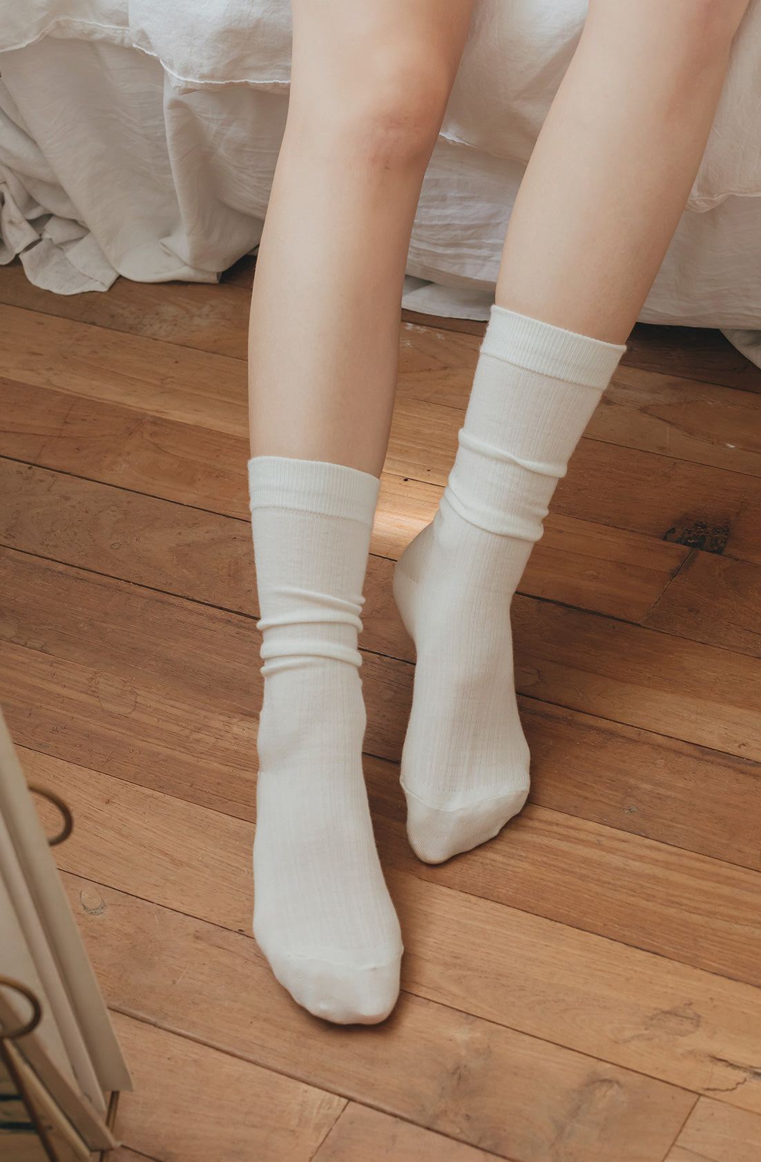 White socks worn on a wooden floor