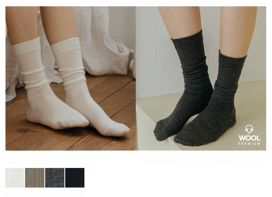 Two pairs of socks, one white and one gray, worn by models on a wooden floor and a white background. Wool Premium logo visible.