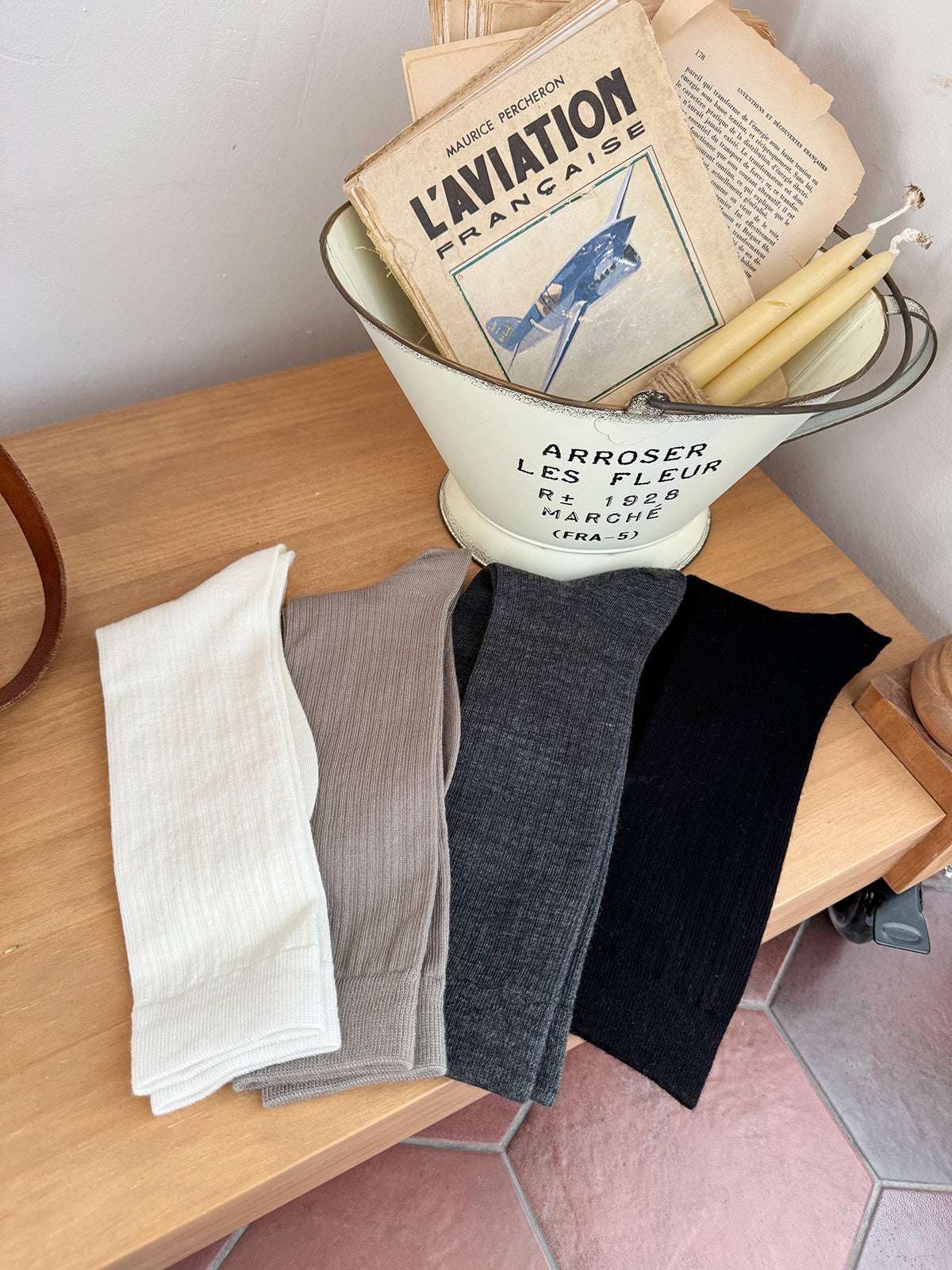 Collection of socks in a vintage-style metal funnel on a wooden surface.