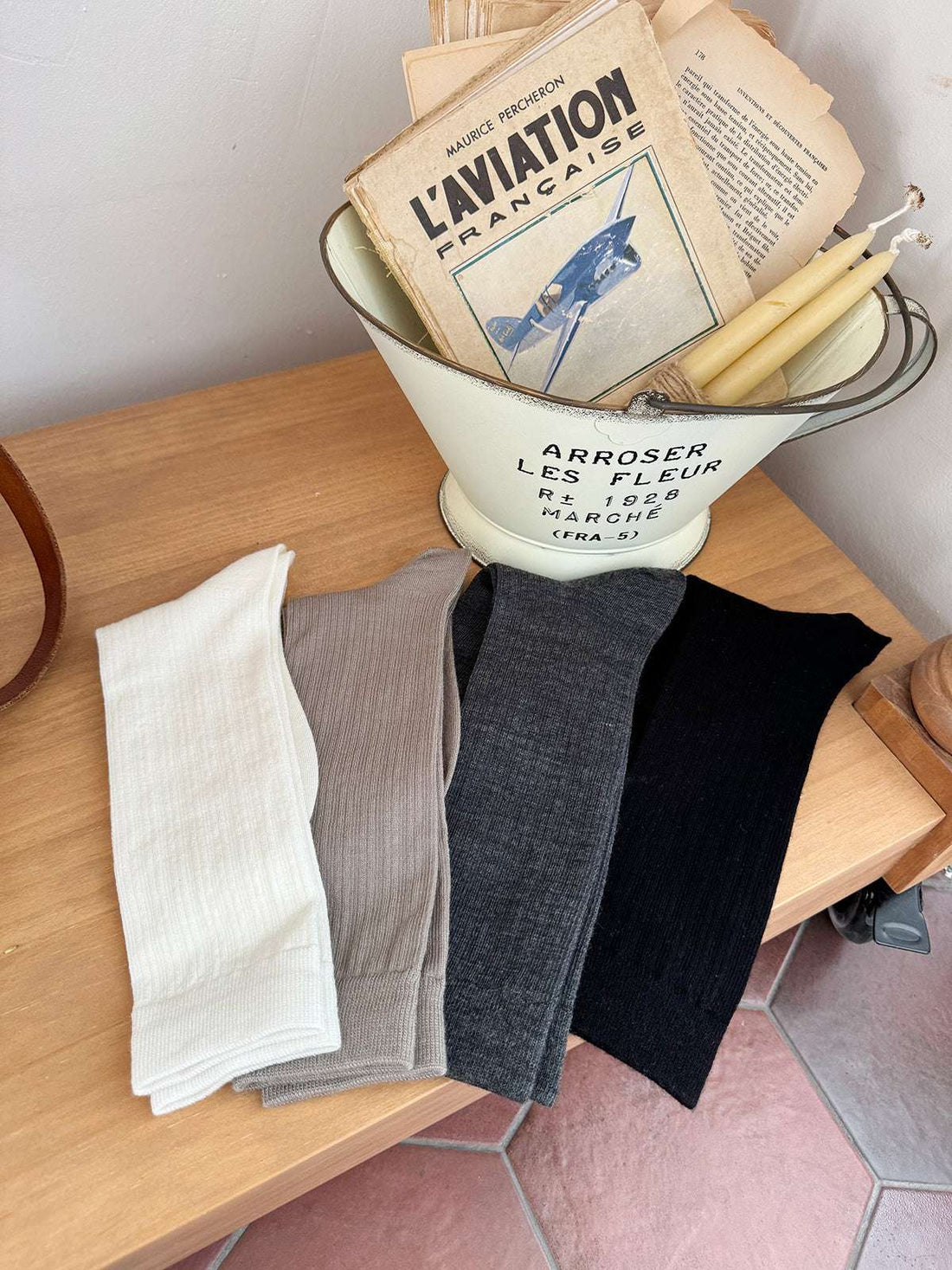 Collection of socks in a vintage-style metal funnel on a wooden surface.
