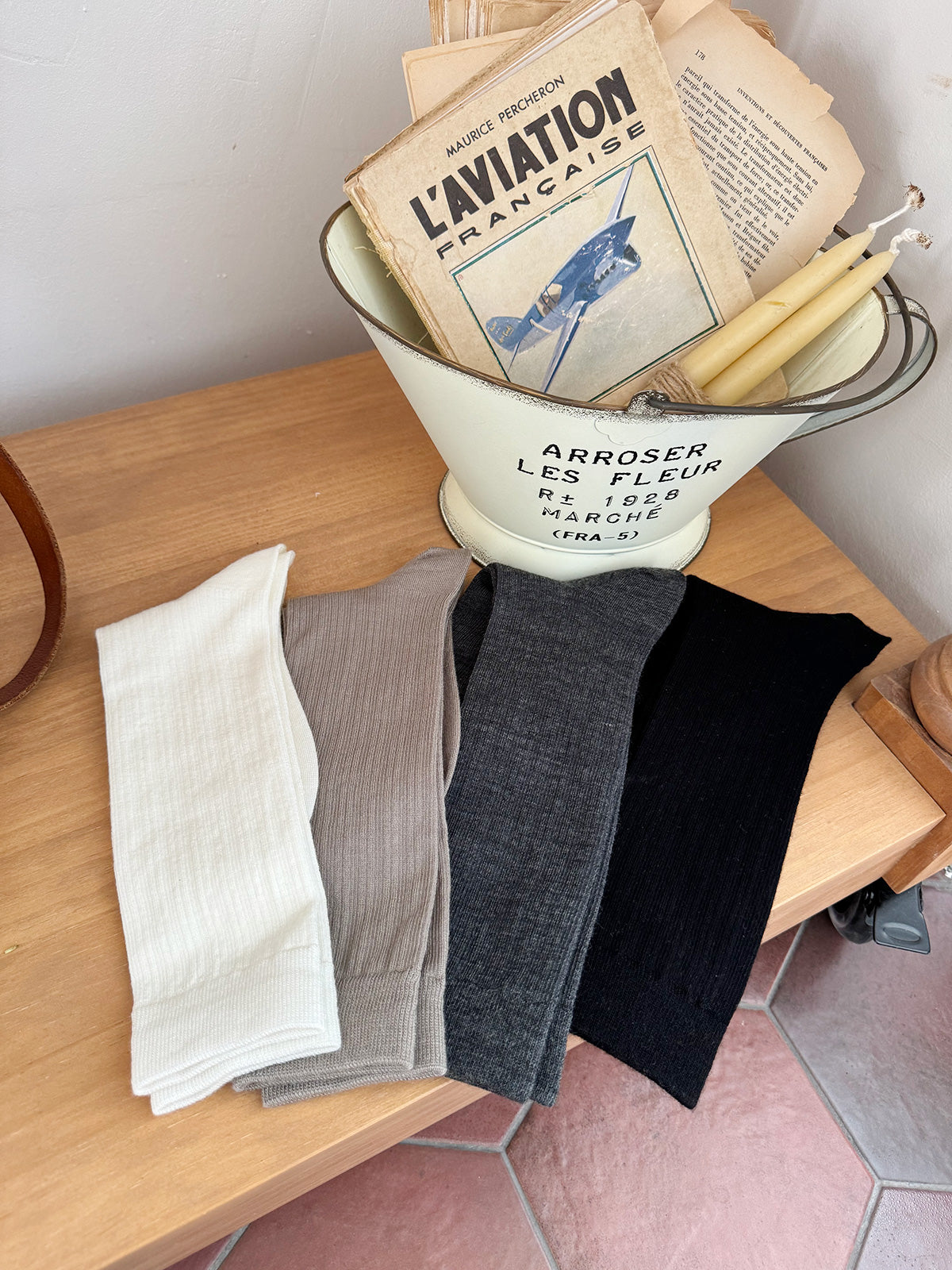 Collection of socks in a vintage-style metal funnel on a wooden surface.