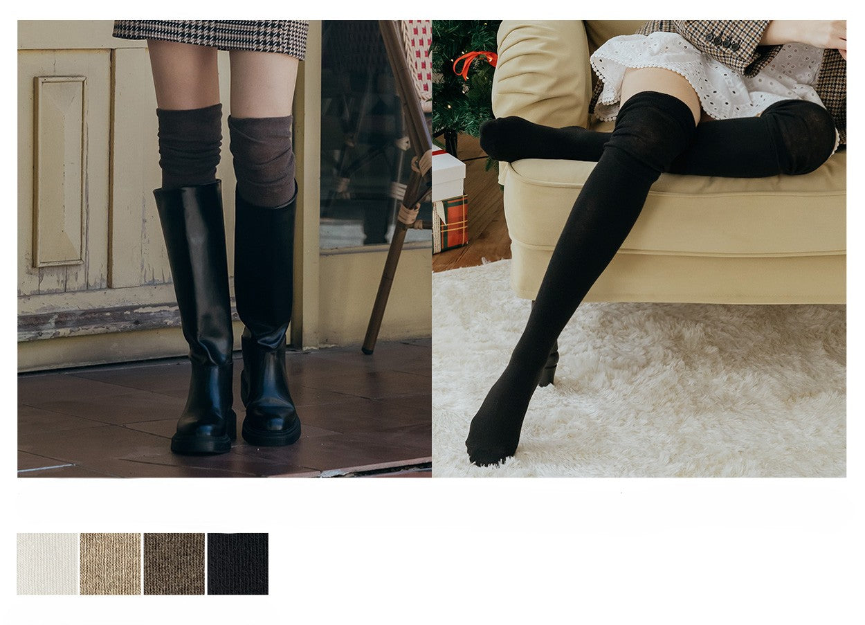 Black knee-high boots and tights worn by a person indoors.