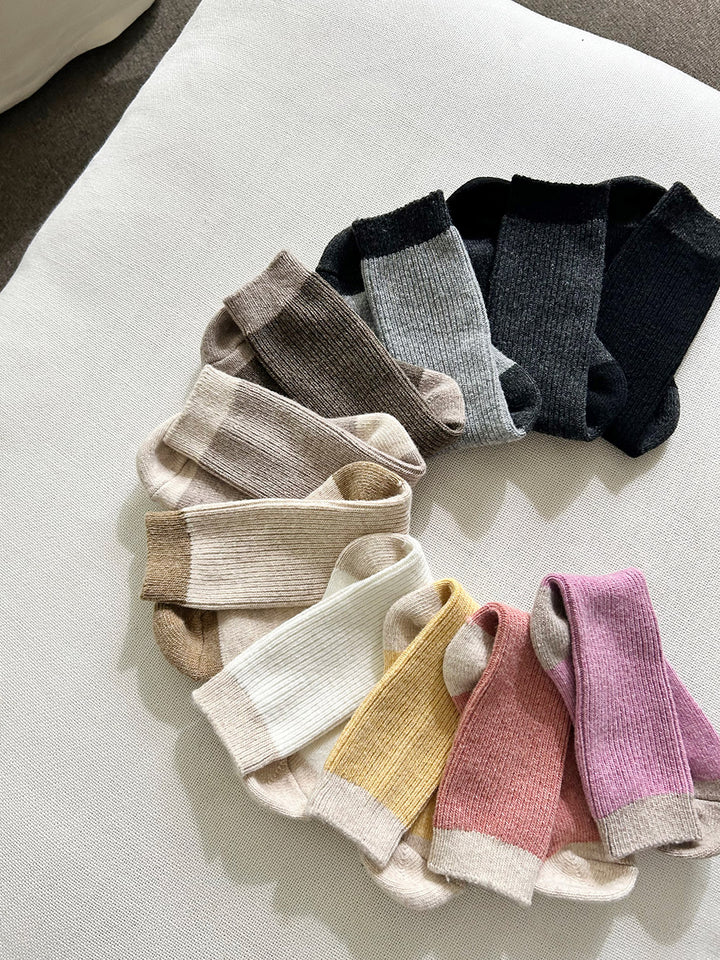 Set of colorful socks arranged in a circular pattern on a light surface.