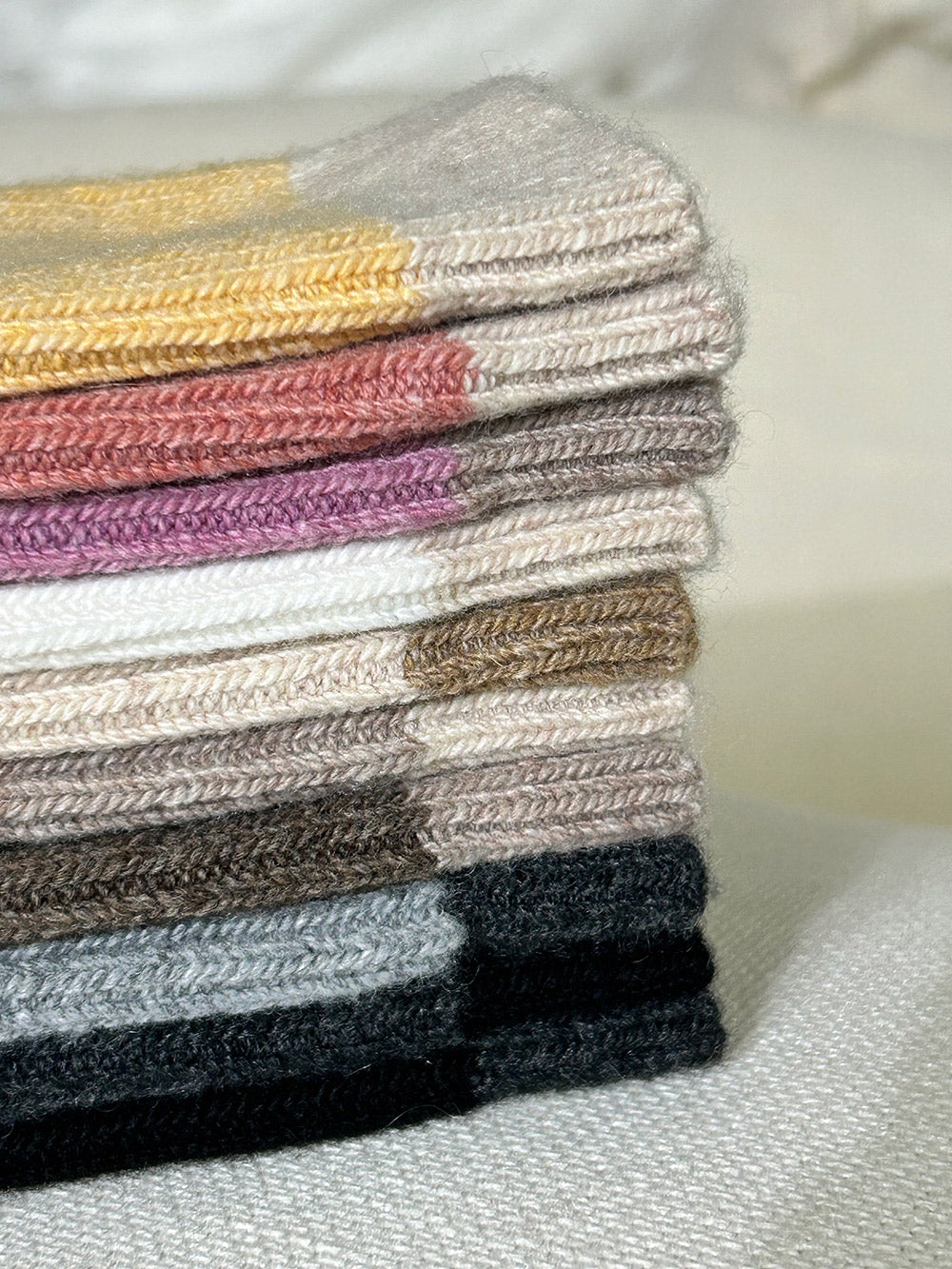 Stack of colorful socks on a light surface