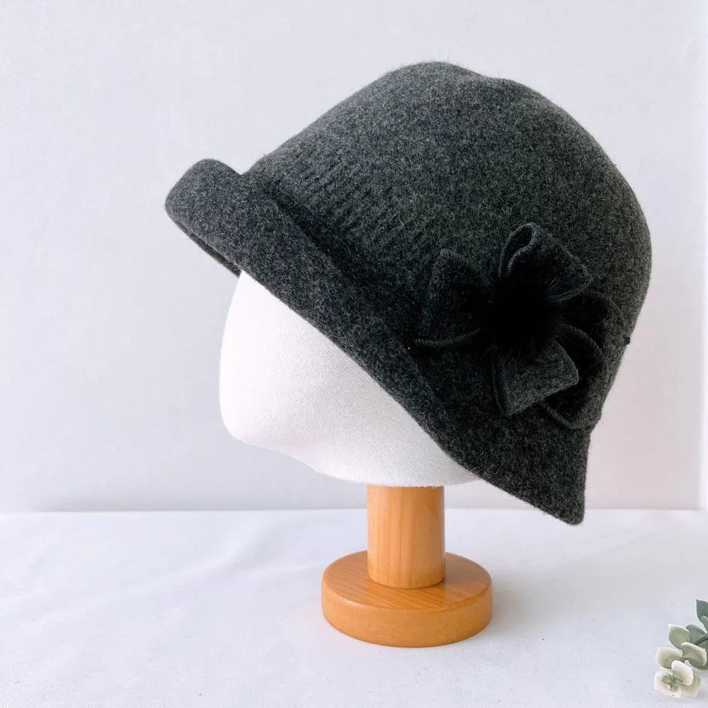 Gray wool cloche hat with a flower detail on the side, displayed on a head form.