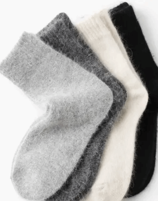 Three pairs of socks in gray, white, and black on a white background