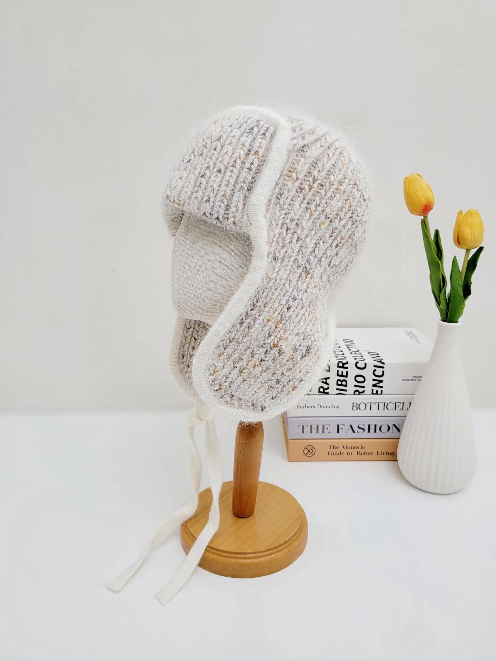 west mountain angora trapper hat: Cream and beige knit hat with ear flaps, white trim, and soft angora ties. Perfect for winter warmth.