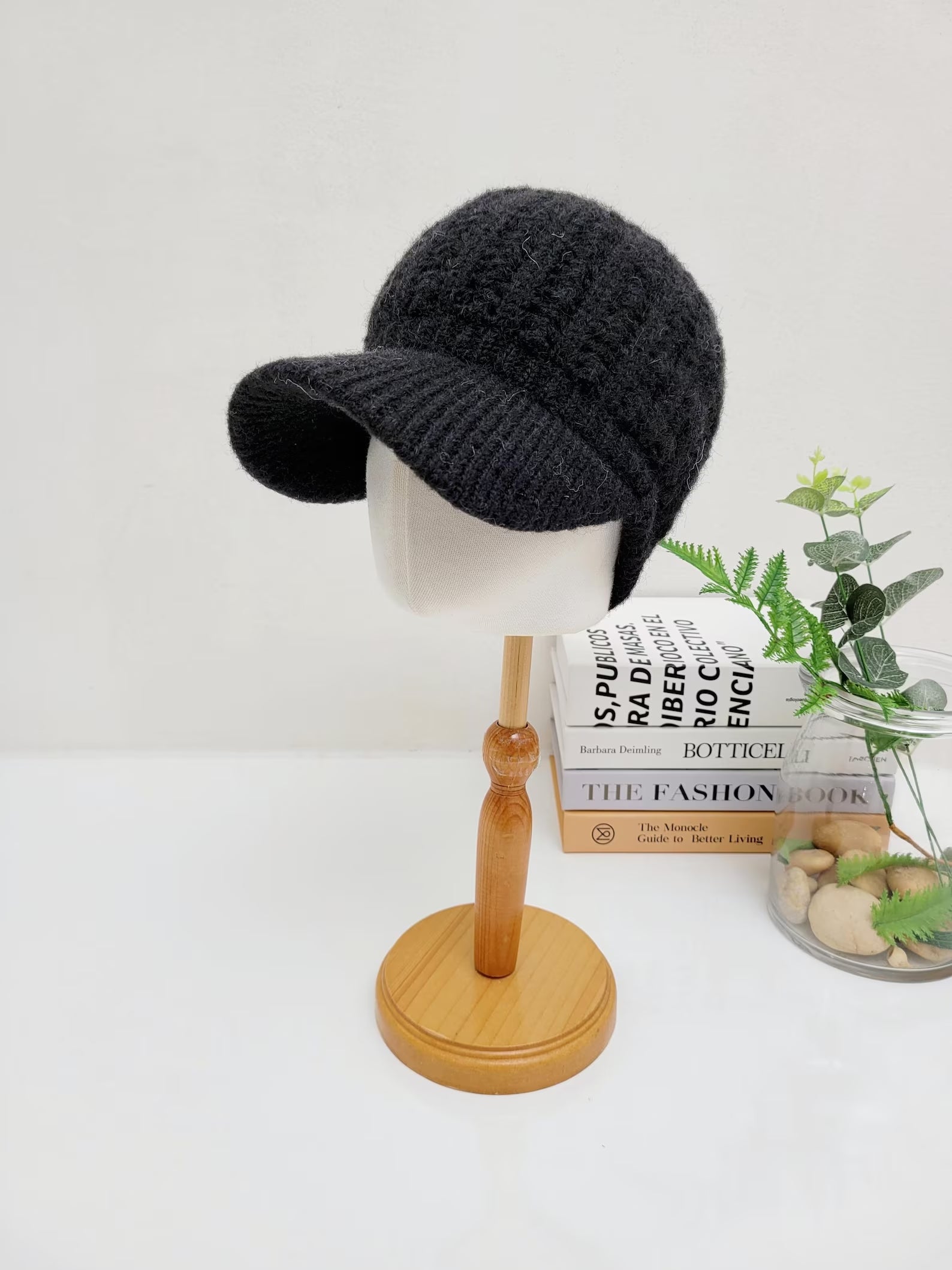 Black crochet baseball cap on a wooden stand, featuring a textured knit design and curved brim.