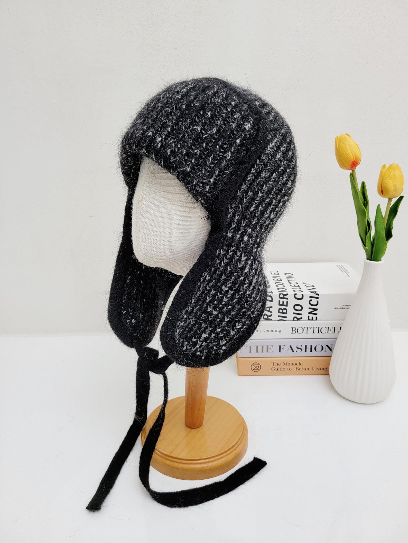 WEST MOUNTAIN ANGORA TRAPPER HAT: Black and gray knit hat with ear flaps and tie closures, shown on a mannequin.