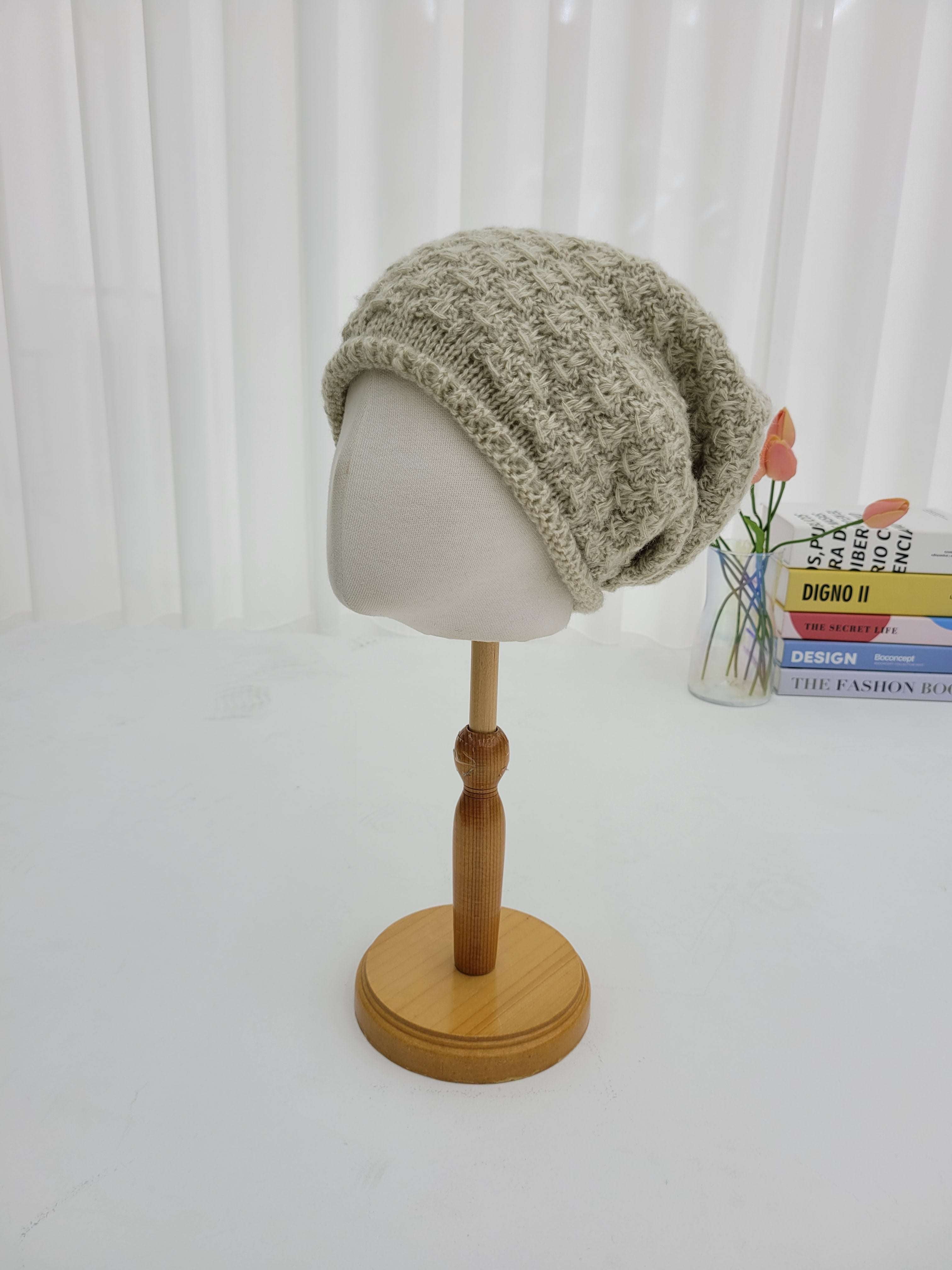 Wooden wall hook with a knitted item on a white background