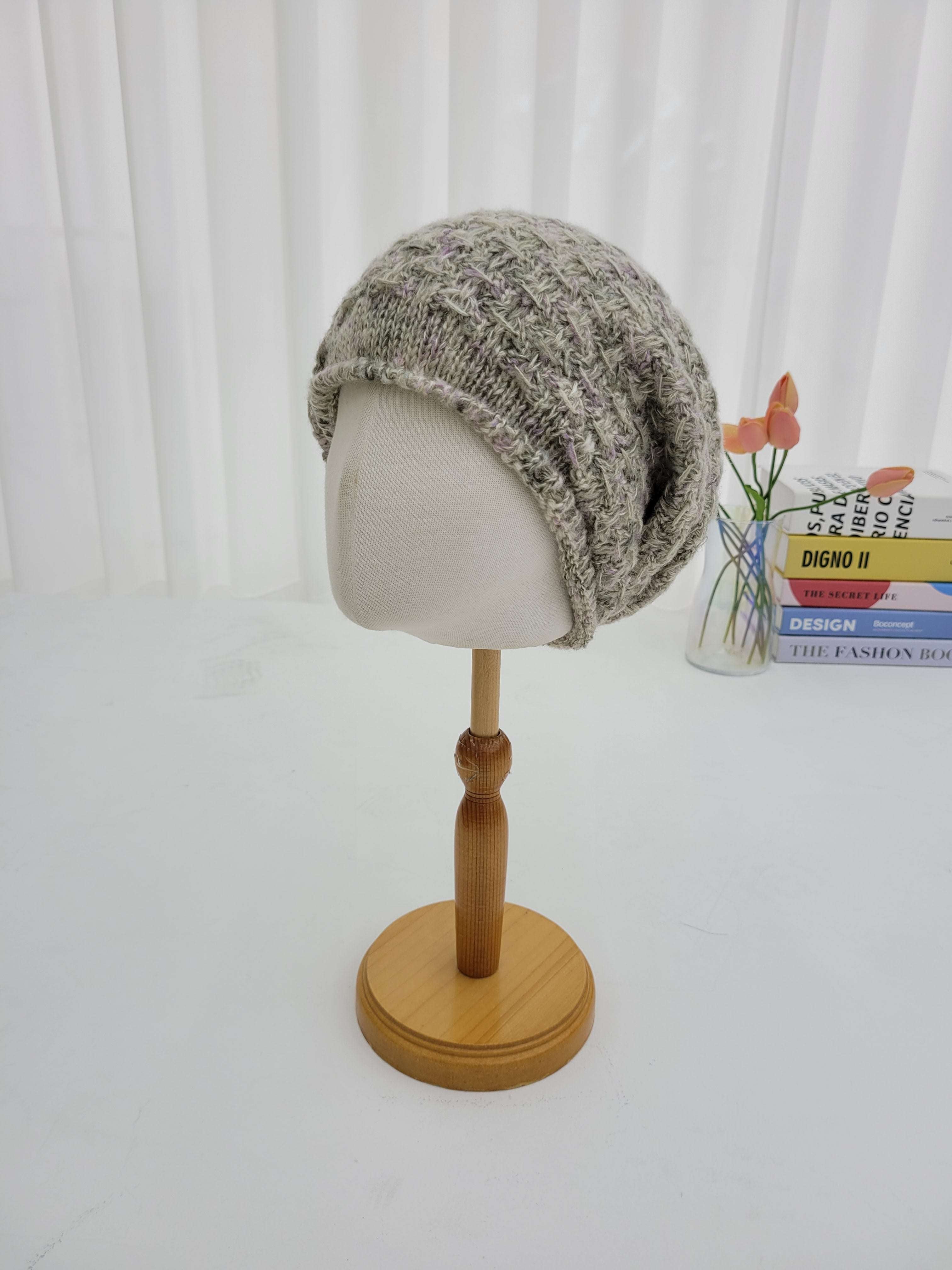 Decorative wall sconce with a textured gray lampshade and wooden fixture on a white wall.