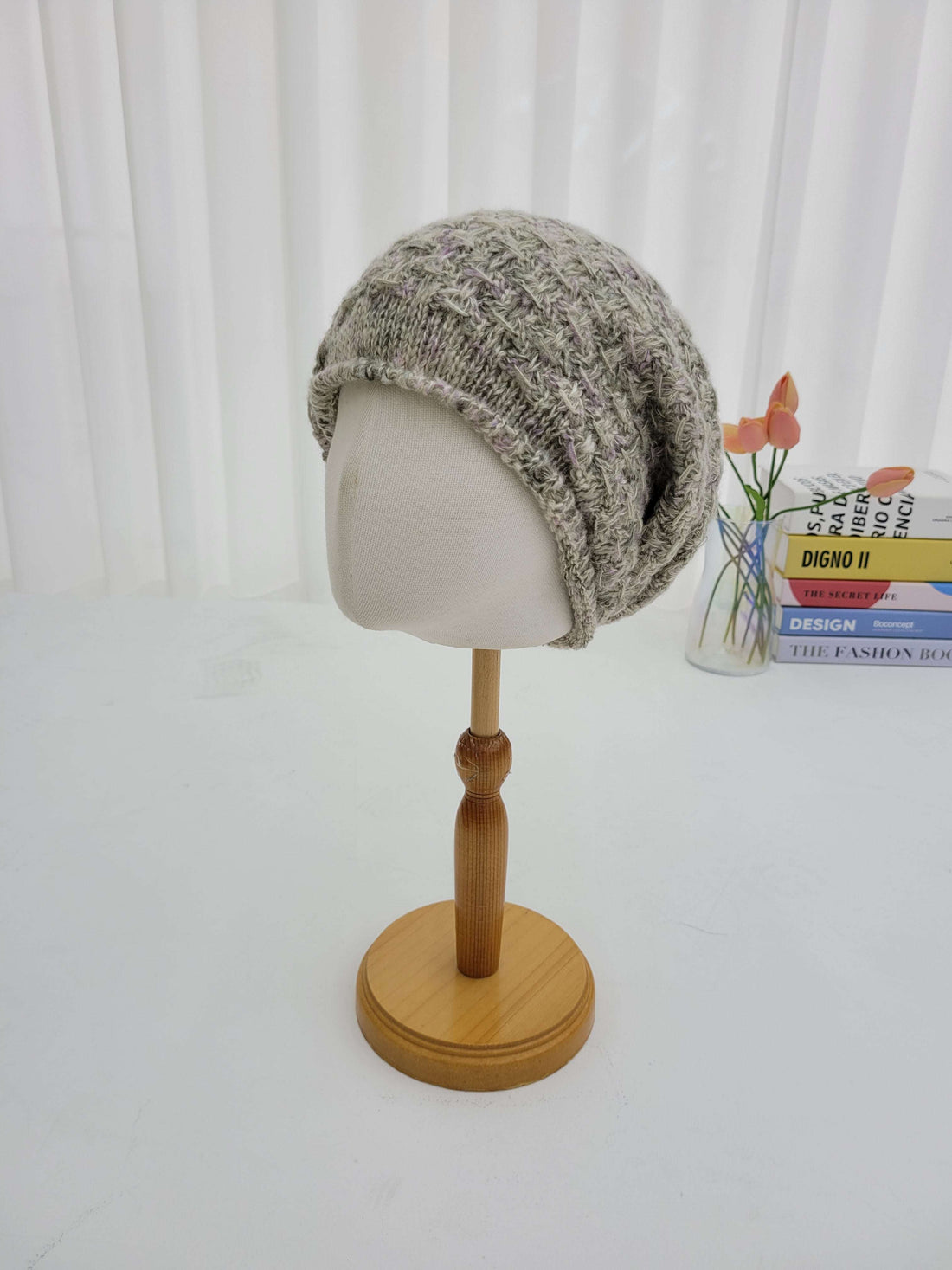 Decorative wall sconce with a textured gray lampshade and wooden fixture on a white wall.