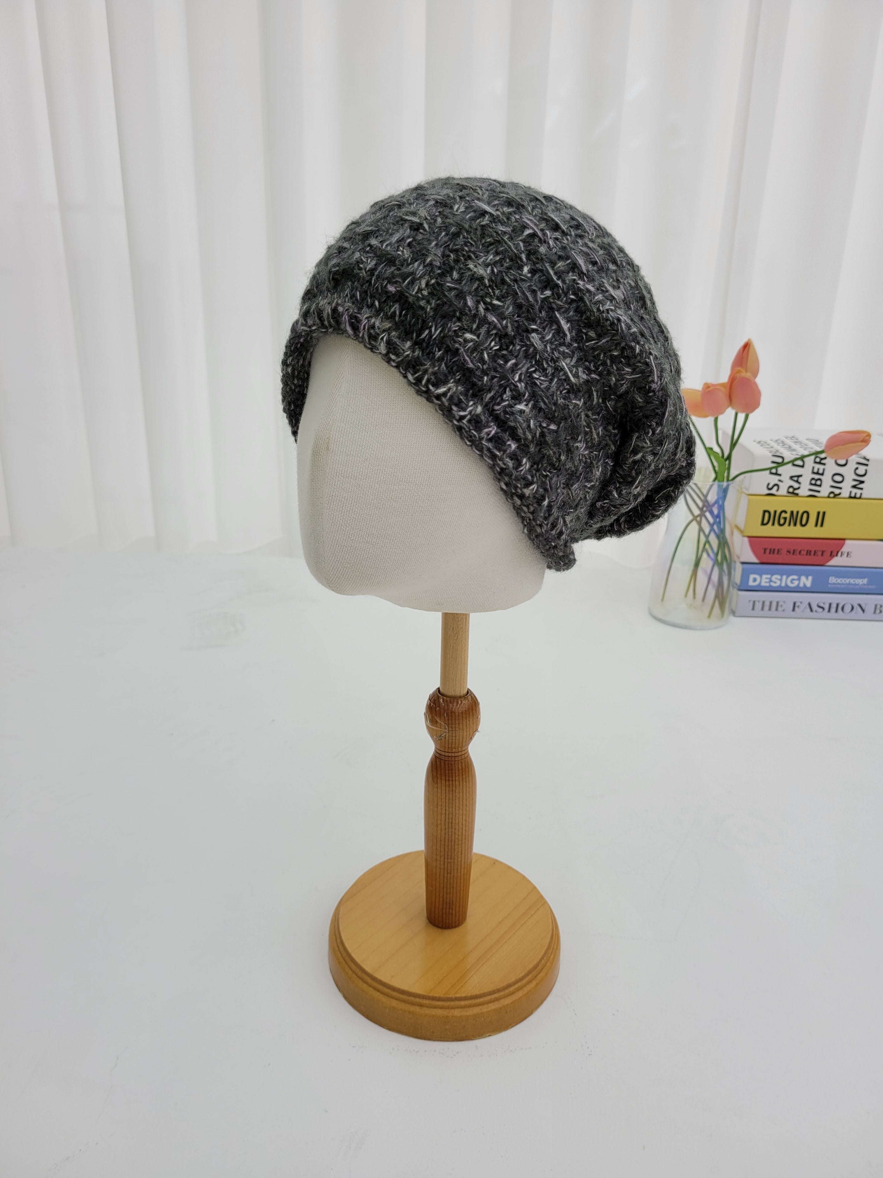 Gray knit beanie on a mannequin head with a wooden stand against a white background