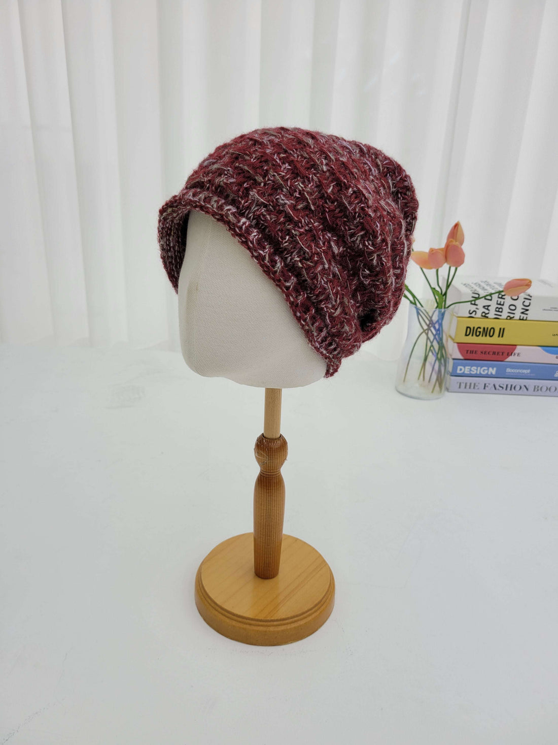 Knitted hat on a mannequin head against a white background