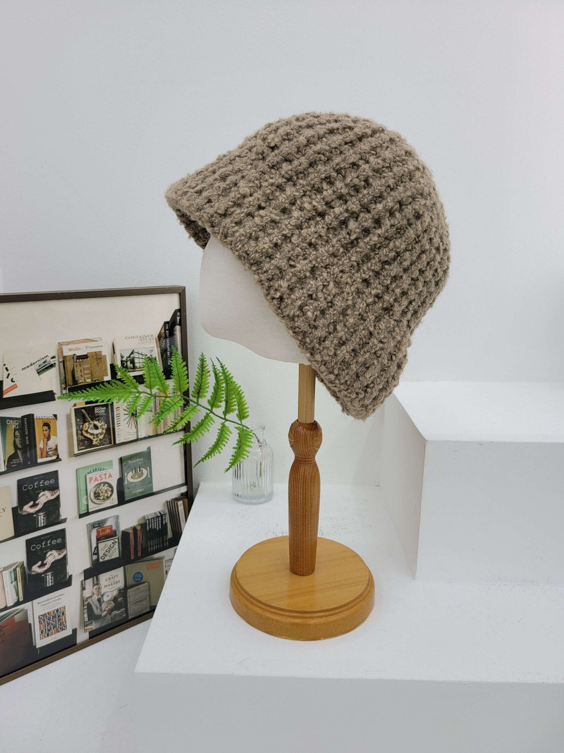 Wall-mounted lamp with a knitted beige shade on a white wall.