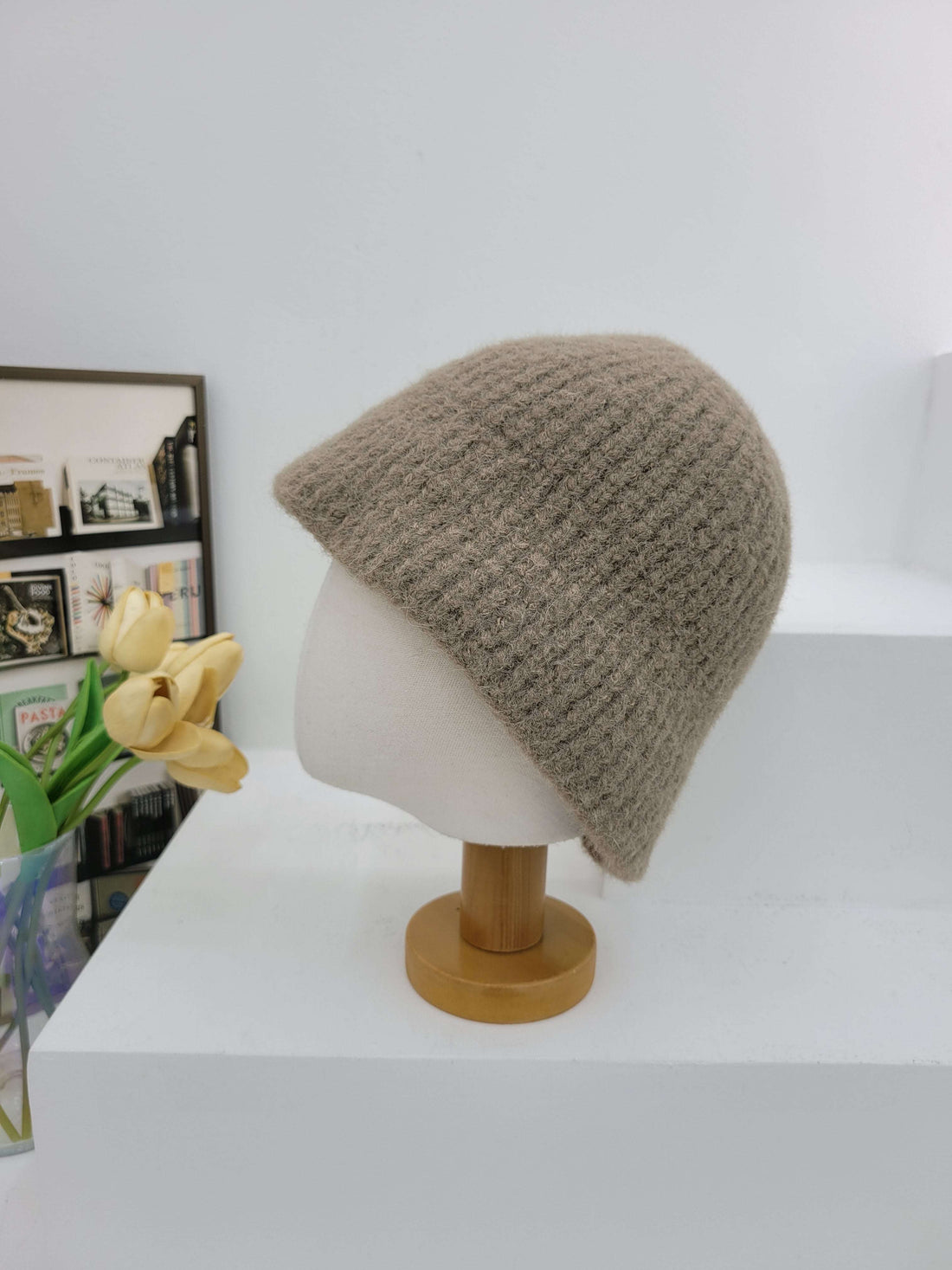 Brown knitted beanie on a mannequin head against a white background