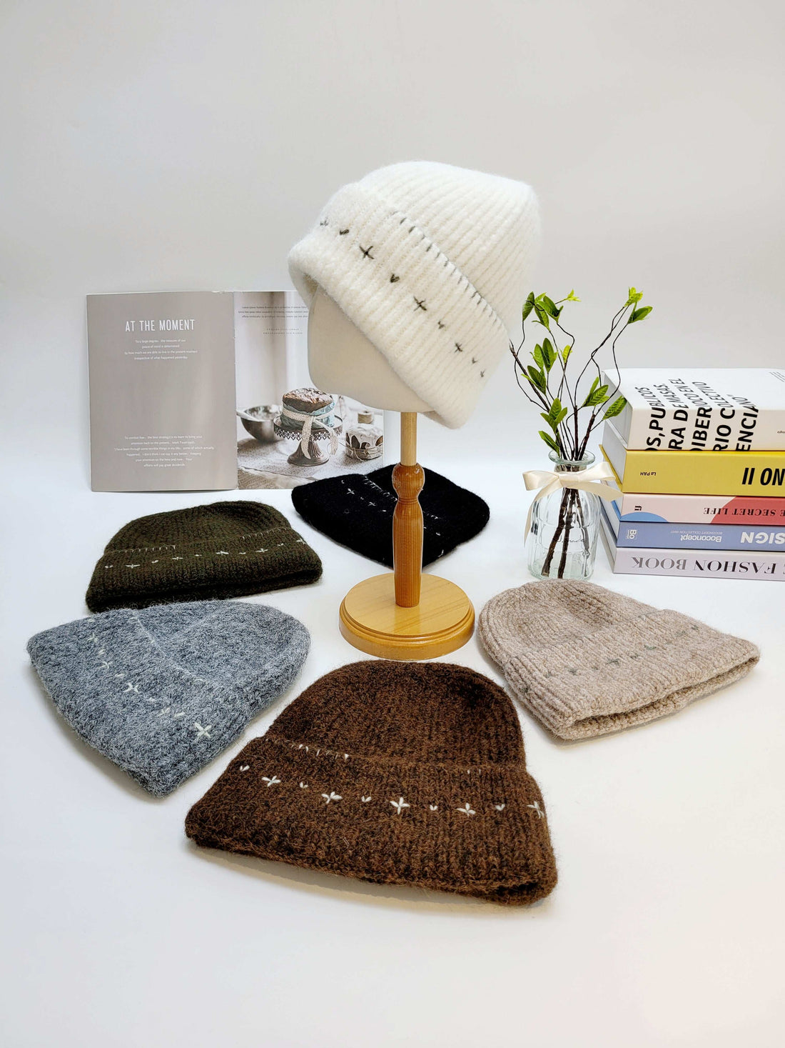 Collection of knit hats on a stand with a minimal background