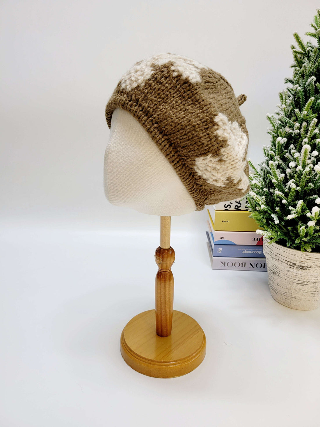 Knitted beanie on a mannequin head with a plant in the background