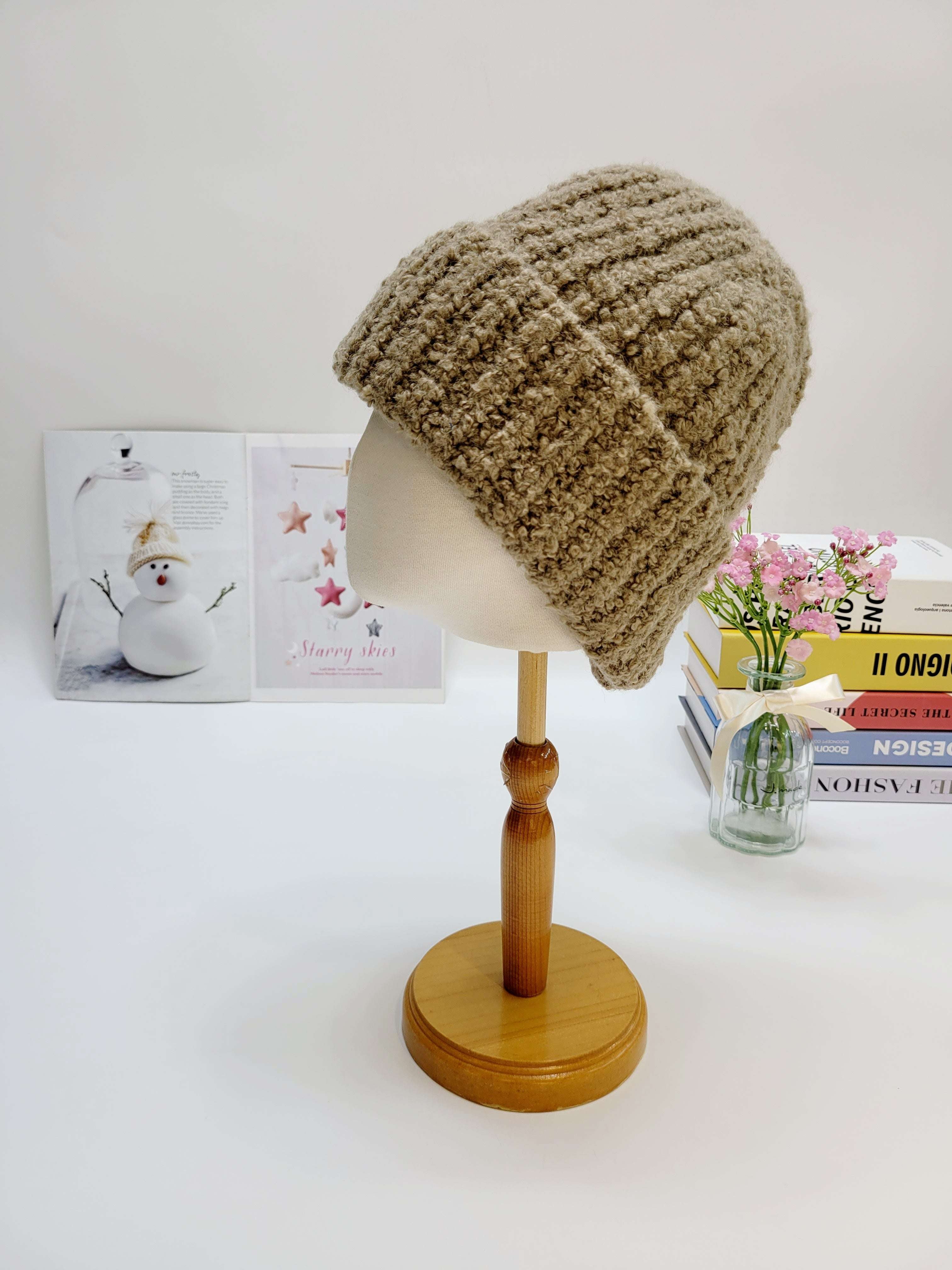 Beige knitted beanie on a mannequin head with a white background