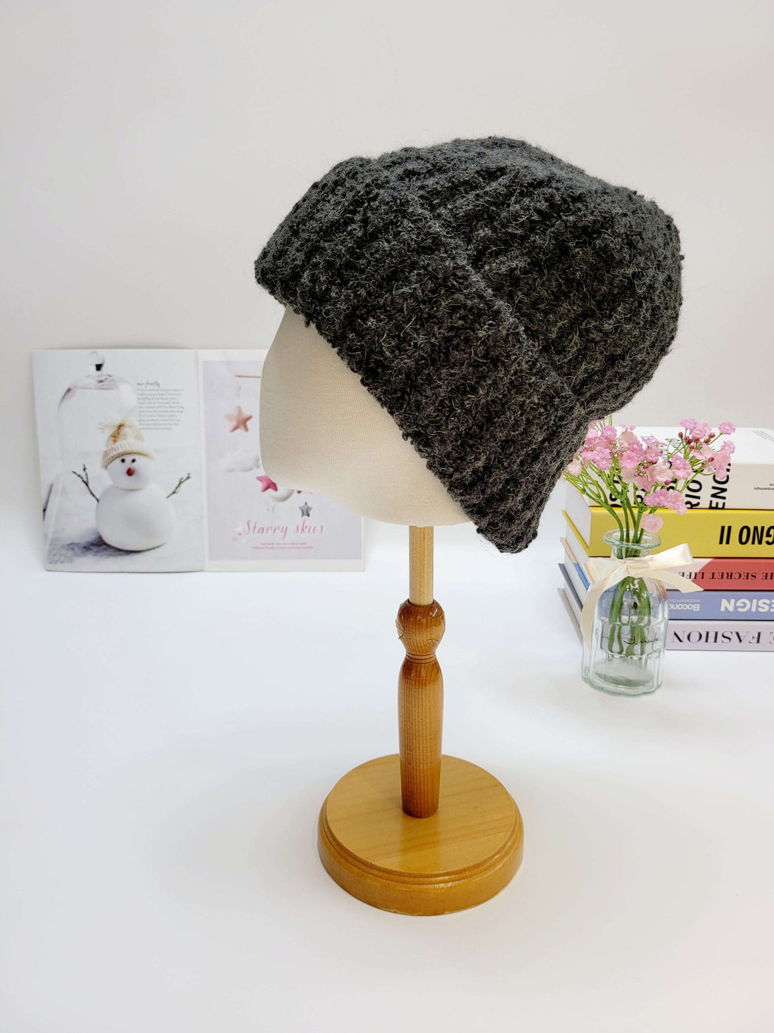 Gray knitted beanie on a mannequin head with a white background