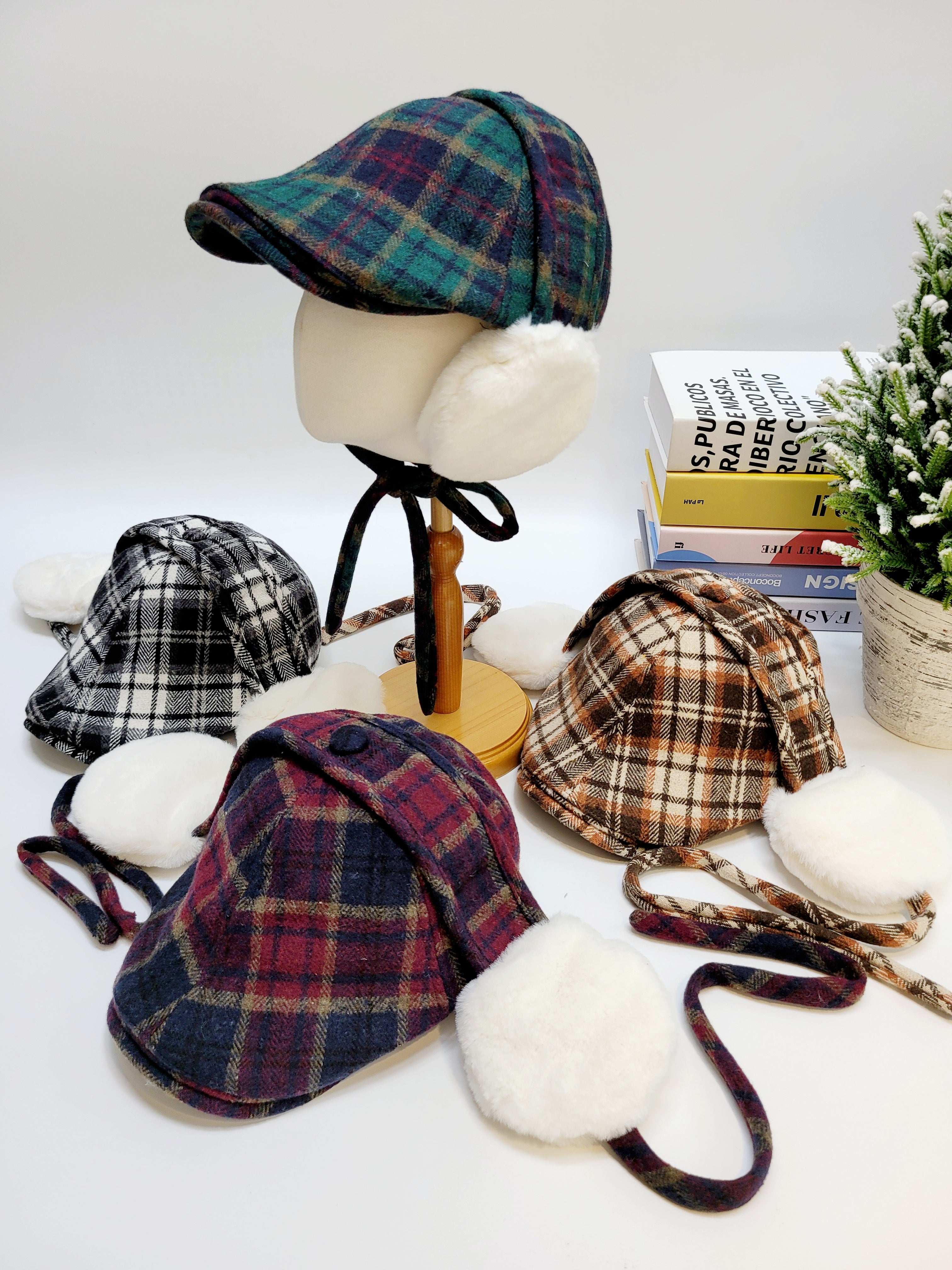 Plaid hats displayed on a mannequin and table with books and a plant in the background.