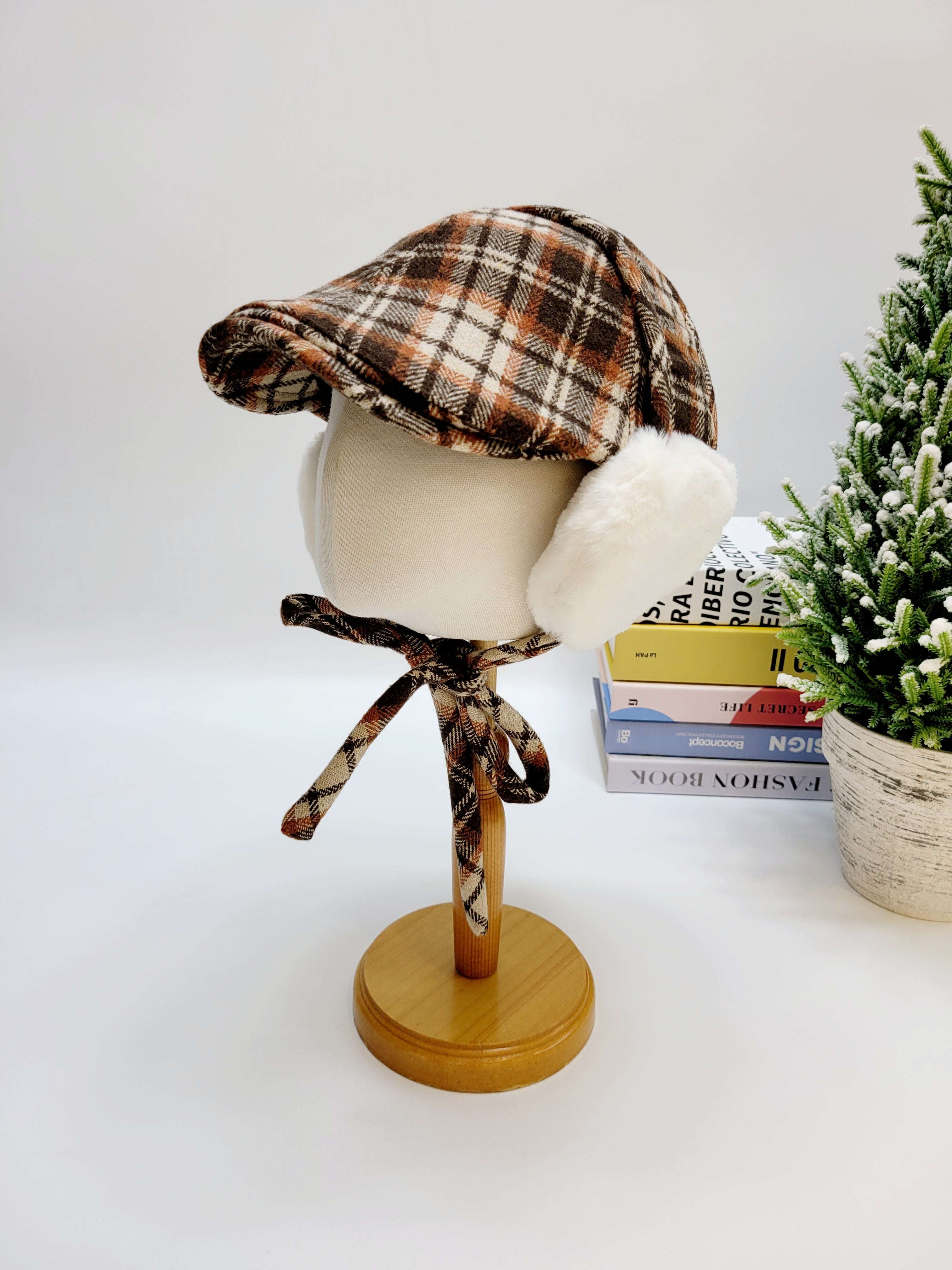 Plaid hat with fur trim on a mannequin head against a white background