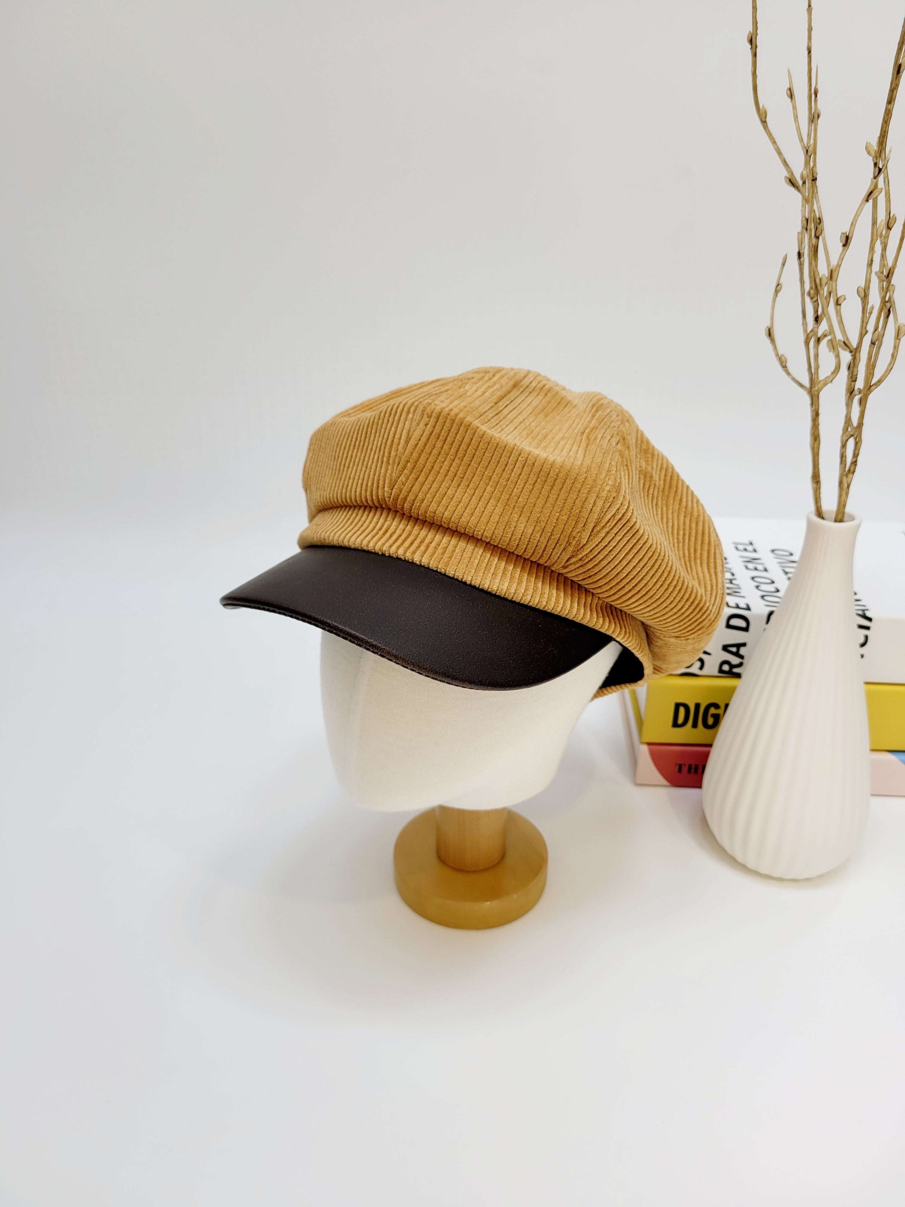 Yellow and black cap on a mannequin head with a white background
