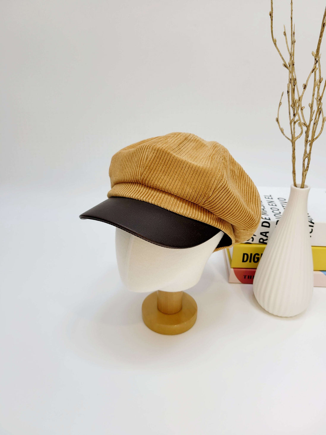 Yellow and black cap on a mannequin head with a white background