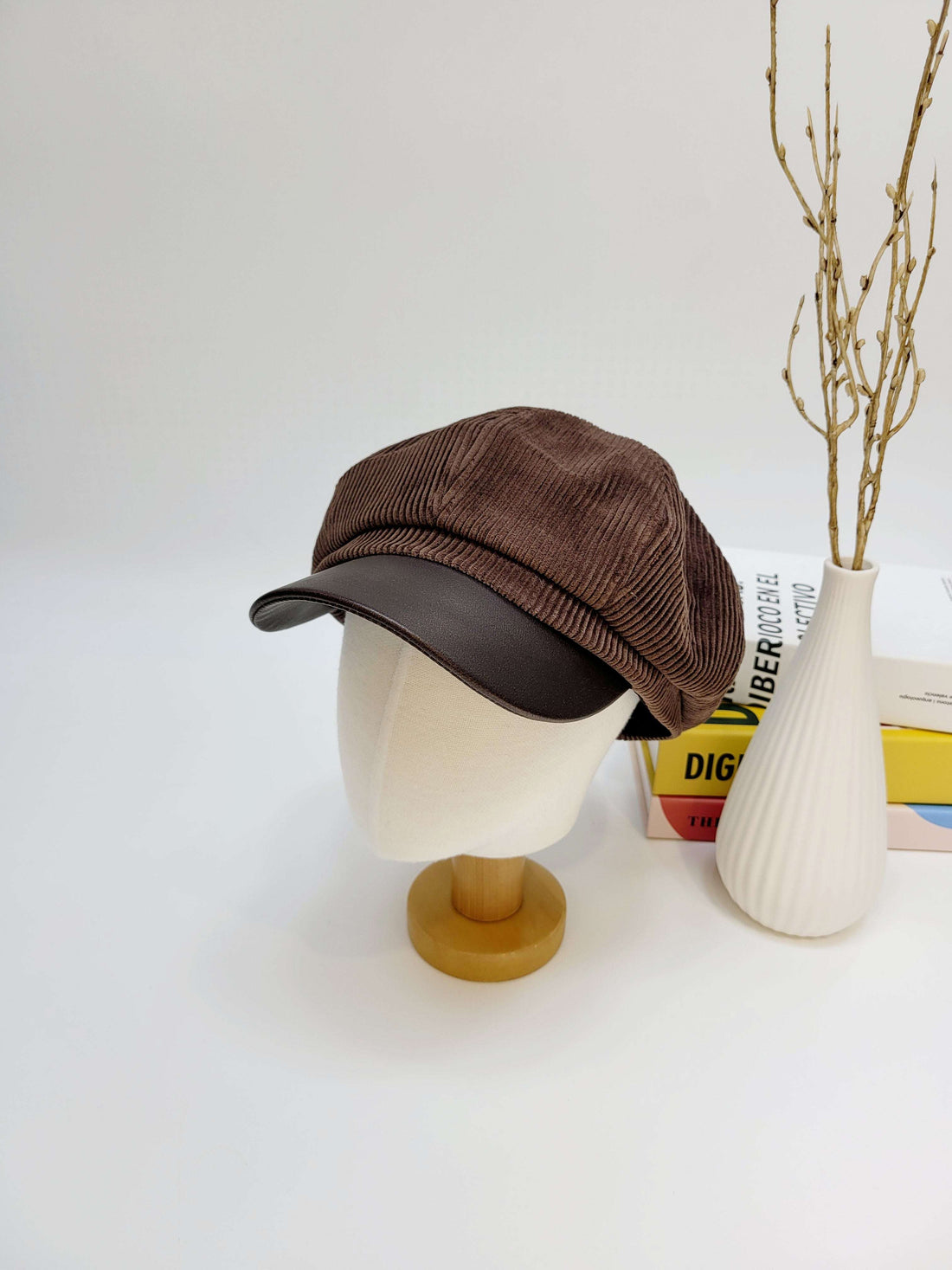 Brown corduroy cap on a mannequin head with a white background
