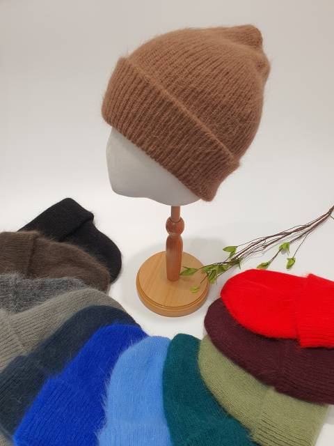 Mannequin head with a brown knitted beanie on a white background