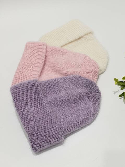 Three knitted beanies in pink, white, and purple on a light background.