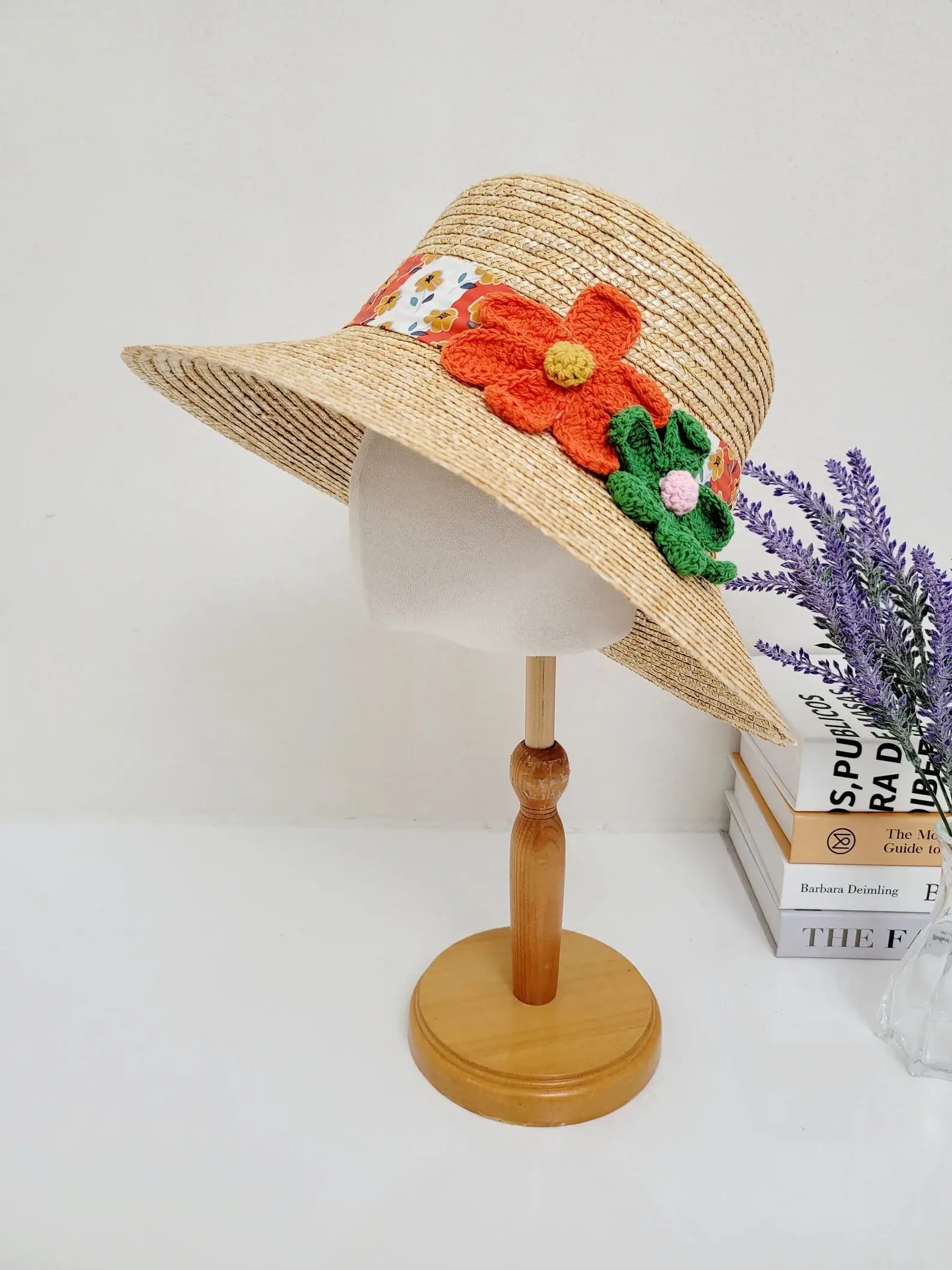 DAISY - straw bucket hat on a mannequin head, featuring a colorful floral band and crochet flower details. Perfect sun protection with style.