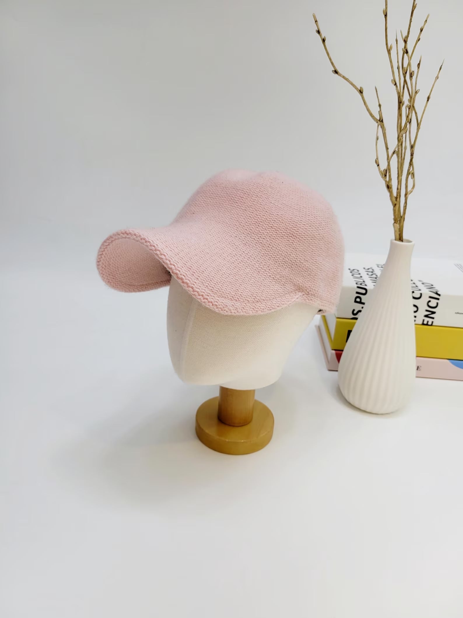 Light pink wool cap with a short brim, displayed on a mannequin head. Soft, knitted texture.