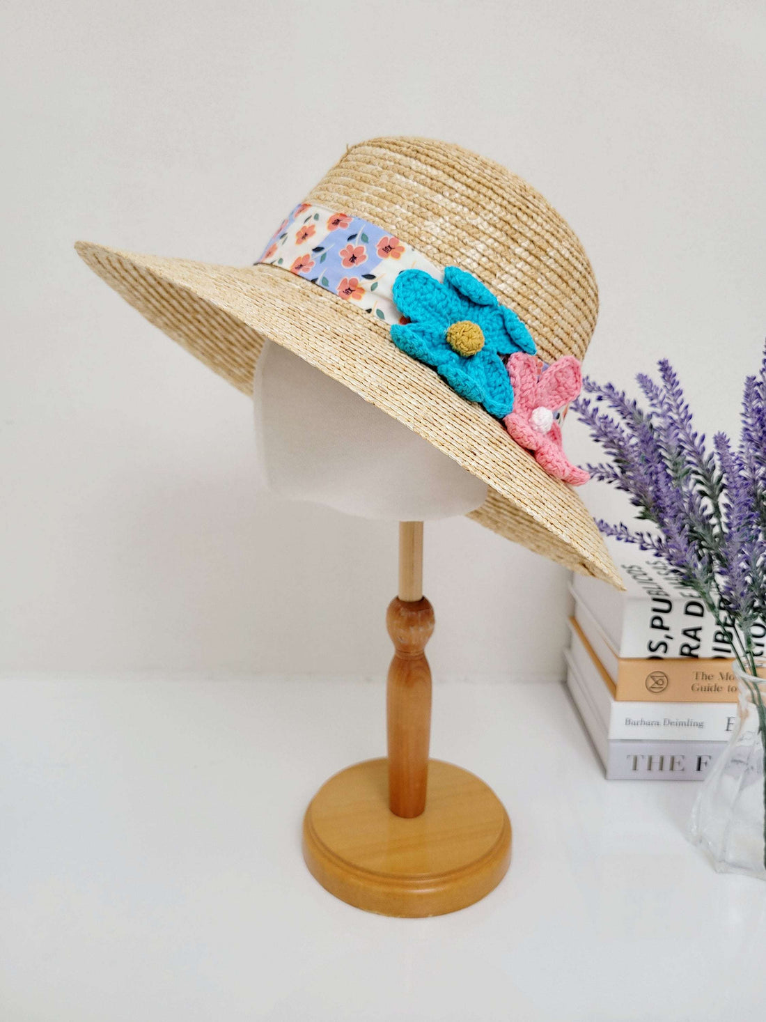 daisy straw bucket hat: Natural straw sun hat with a floral-print band and handmade crocheted flower accents in blue and pink
