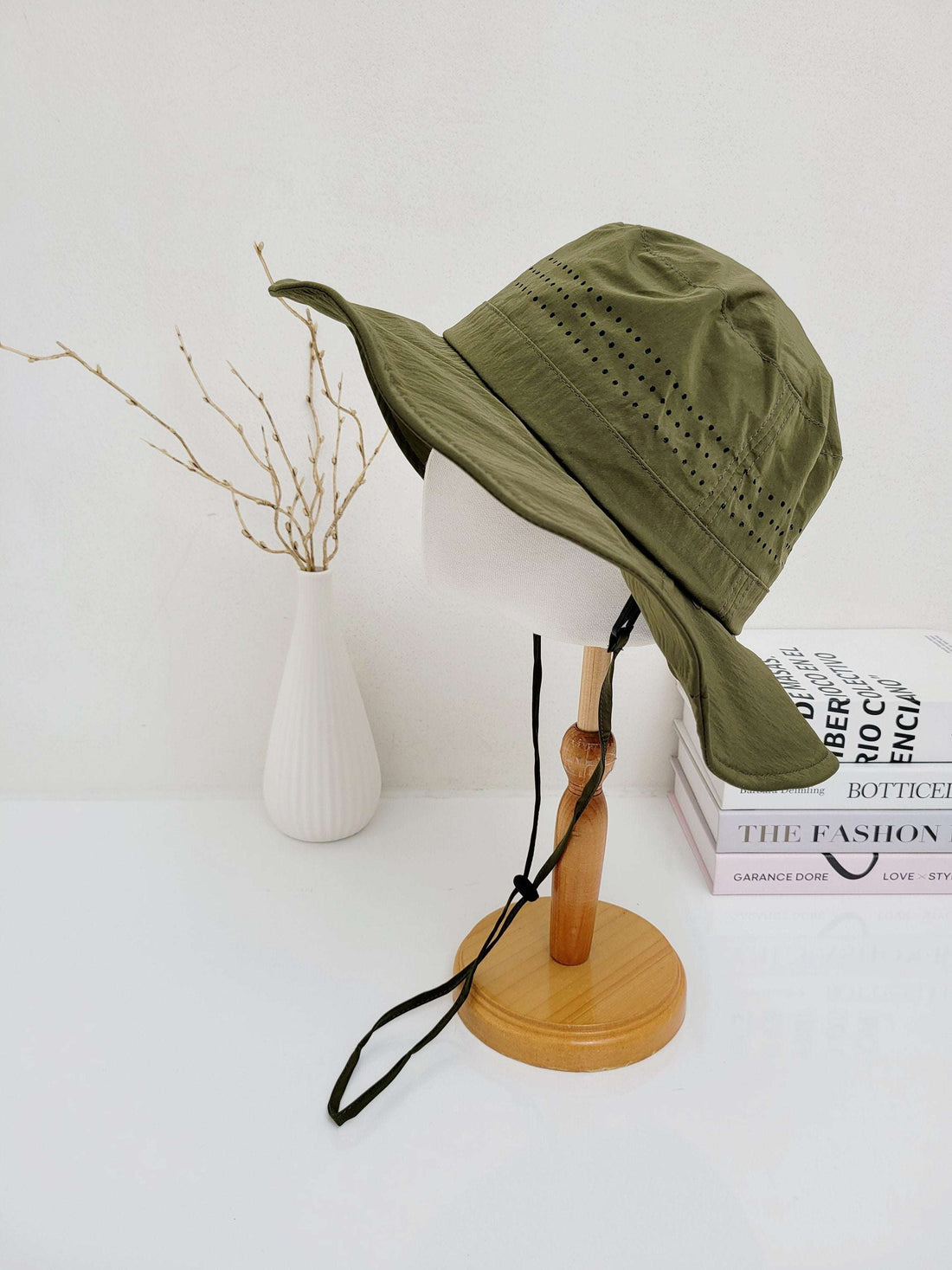 Olive green bucket hat, part of the long journey collection, featuring an adjustable chin strap and perforated ventilation.