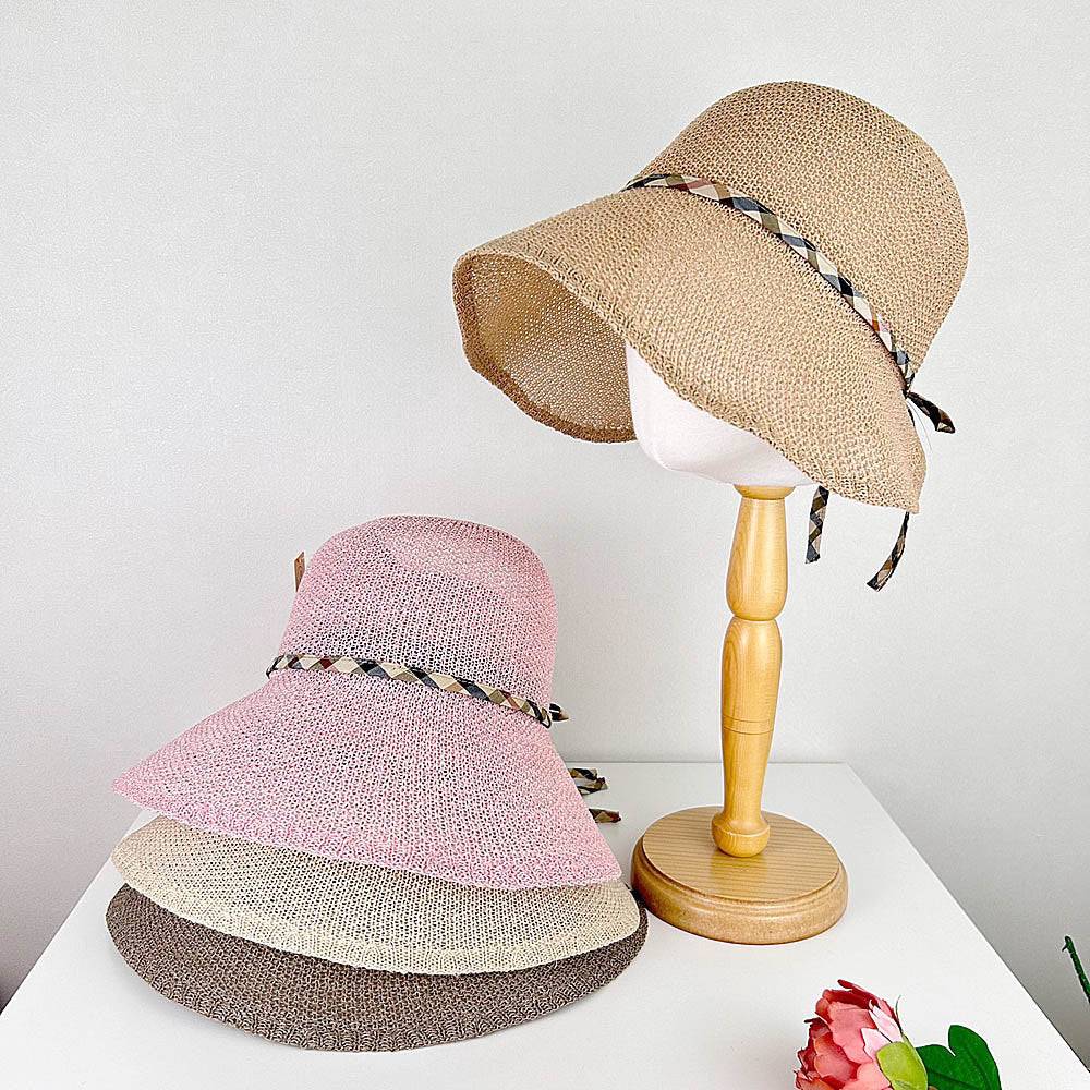 kelly's picnic sun hats: Stack of brown, beige, and pink summer hats, plus a tan straw hat on a wooden stand, perfect beach hats for women.