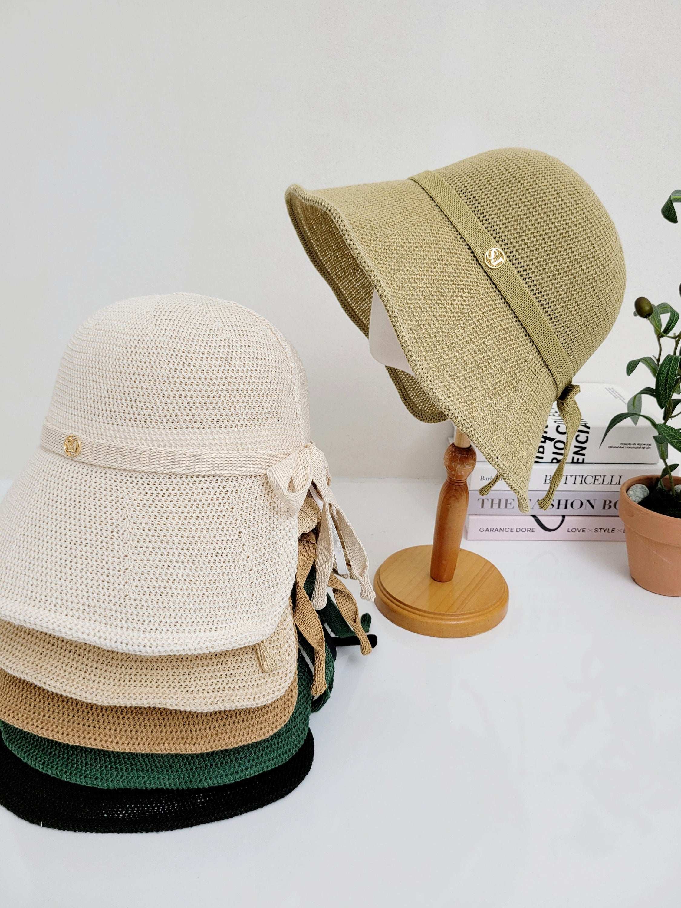 SJ sun hats: Stack of colorful sun hats and one on a stand.