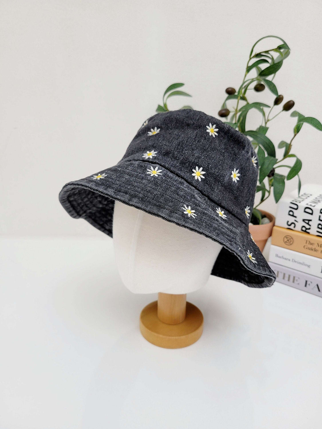 black daisy denim bucket hat with embroidered white daisies, perfect for sun protection and a stylish look.