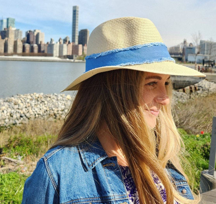 long island straw hat with blue band, worn with denim jacket against city skyline, perfect summer sun hat