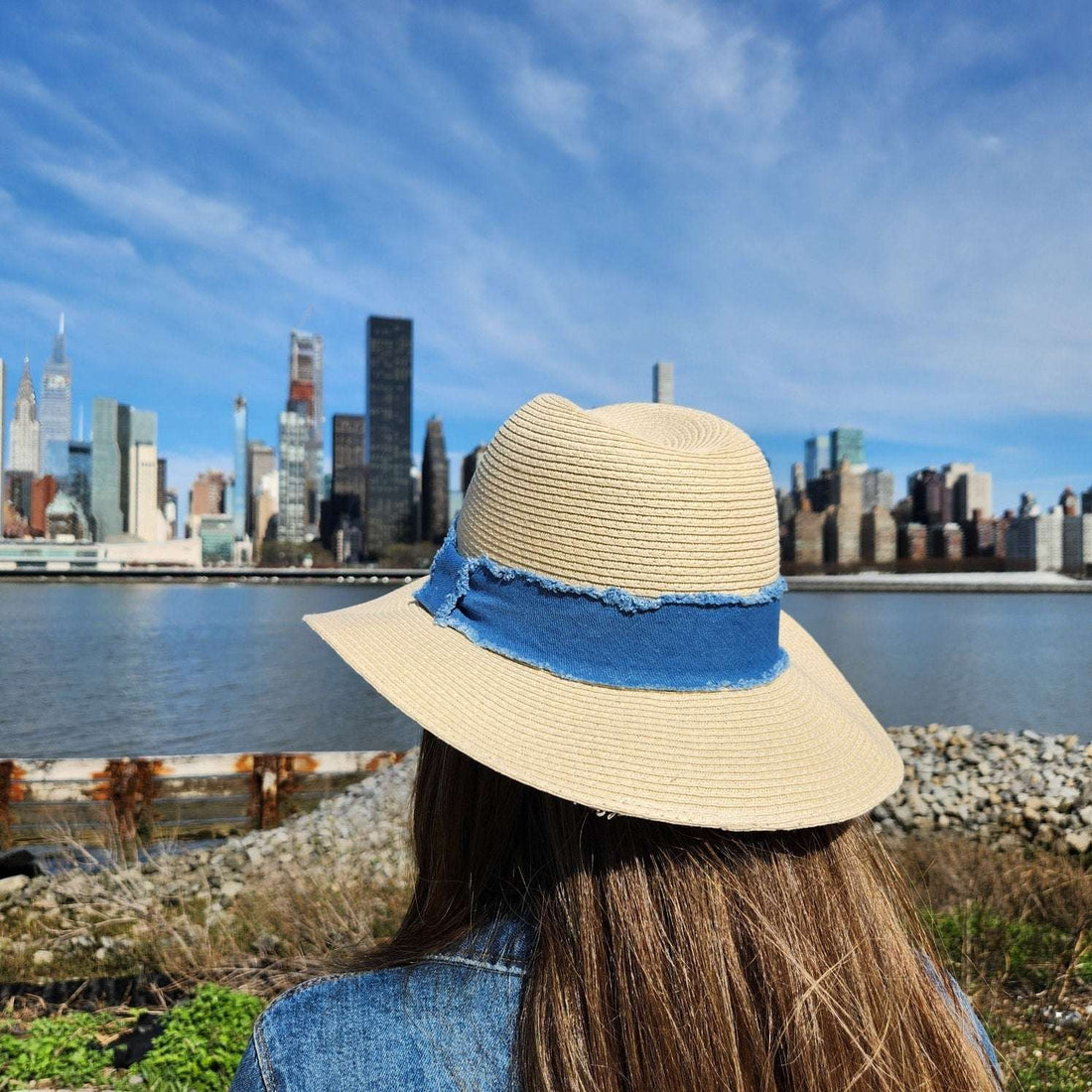 LONG ISLAND straw hat with a frayed denim band, offering stylish sun protection for travel or a day at the beach