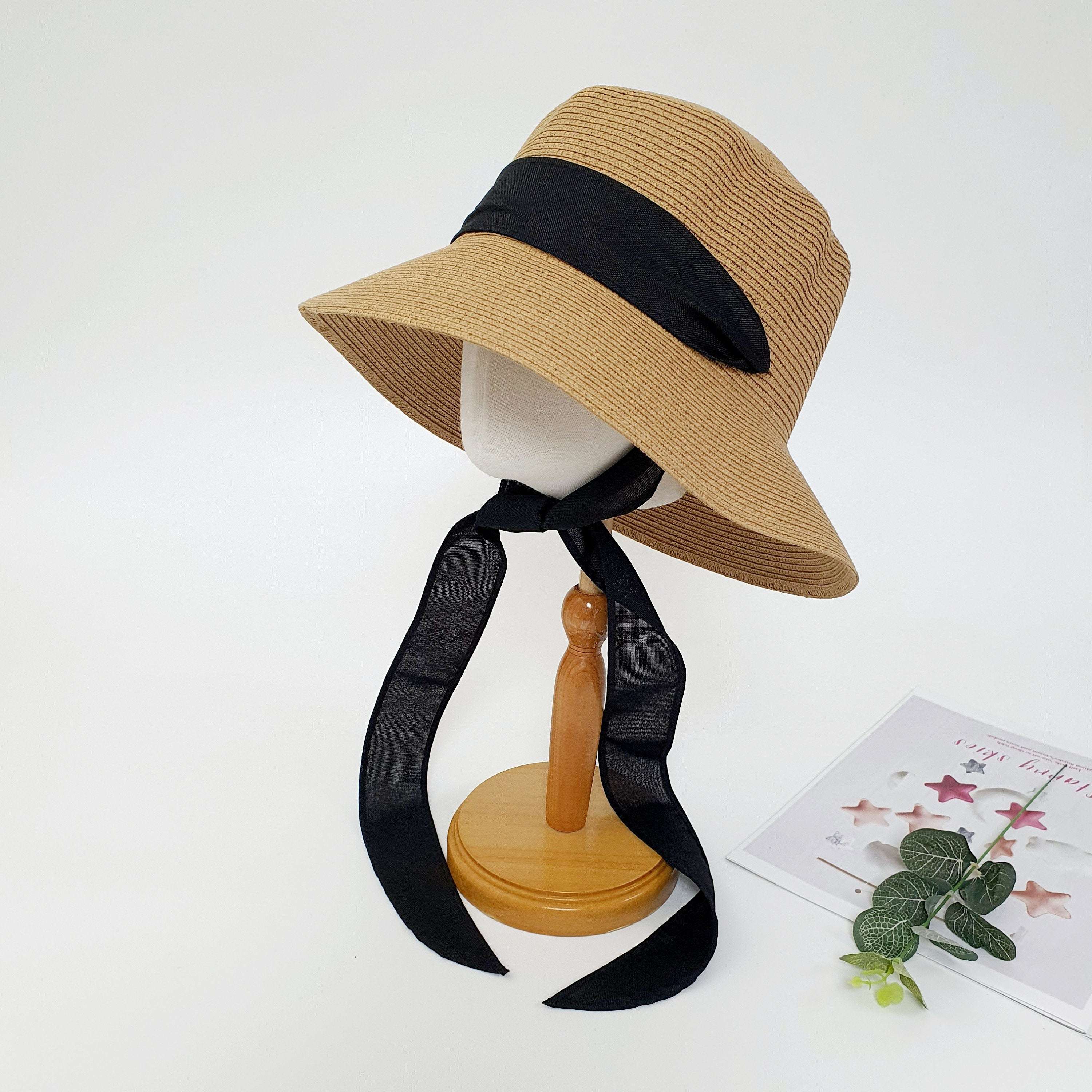 PENELOPE straw sun hat with wide brim and stylish long black ribbon detail, displayed on a mannequin.