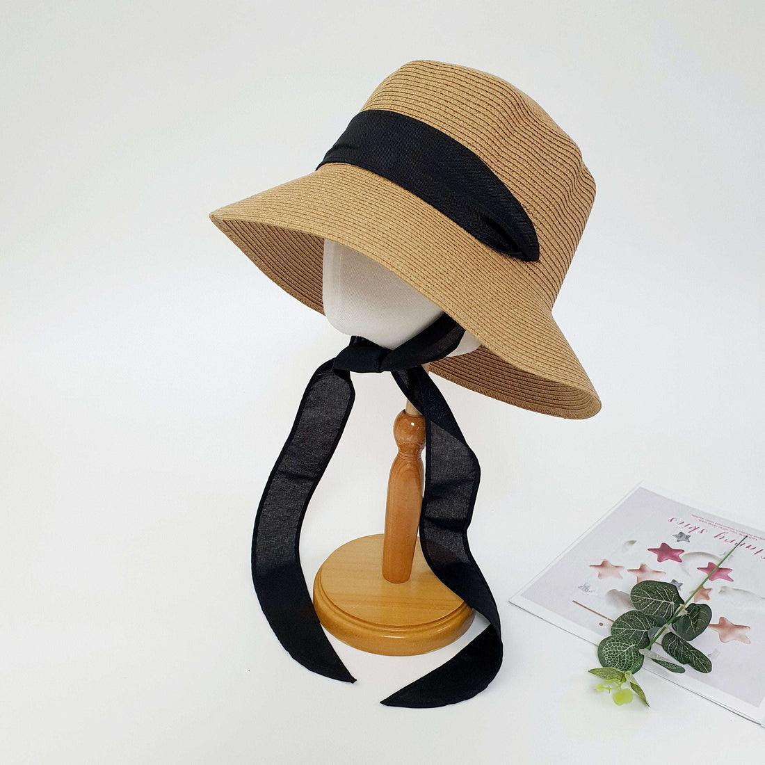 PENELOPE straw sun hat with wide brim and stylish long black ribbon detail, displayed on a mannequin.