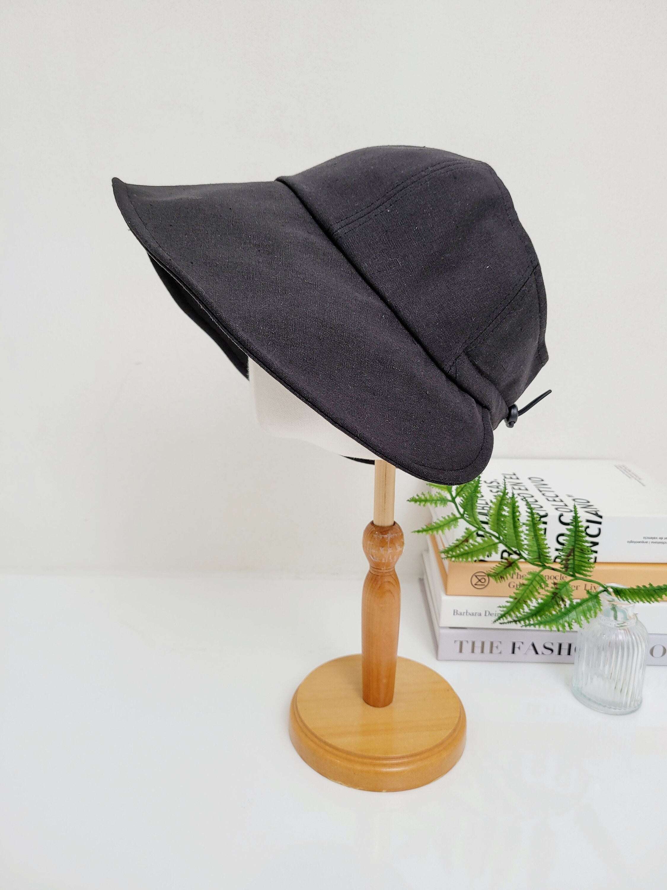 Black solid linen - summer sun hat on mannequin head, featuring a wide brim and adjustable tie detail for sun protection and style.