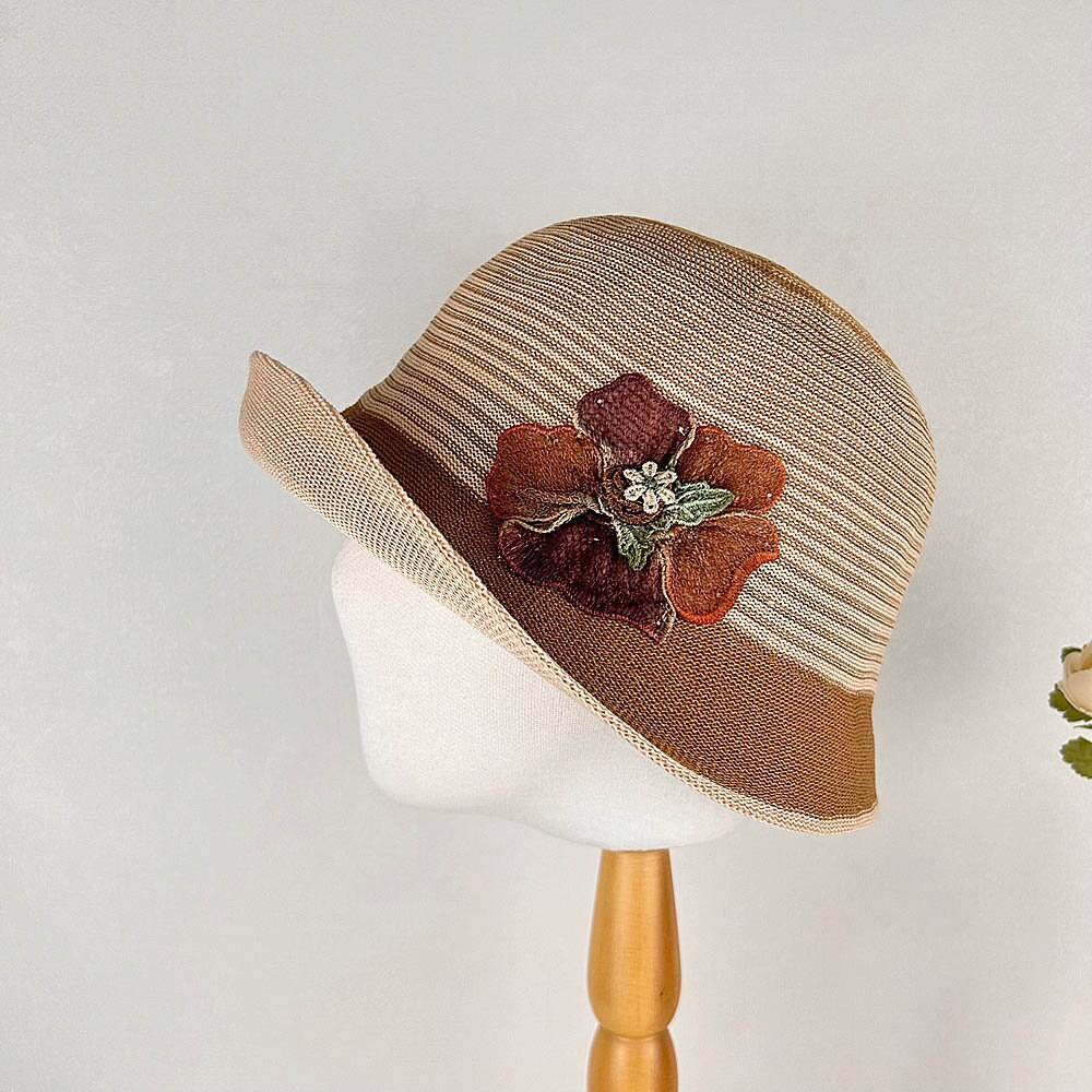 Striped brown floral crown hat with a dark brown flower accent, displayed on a mannequin head