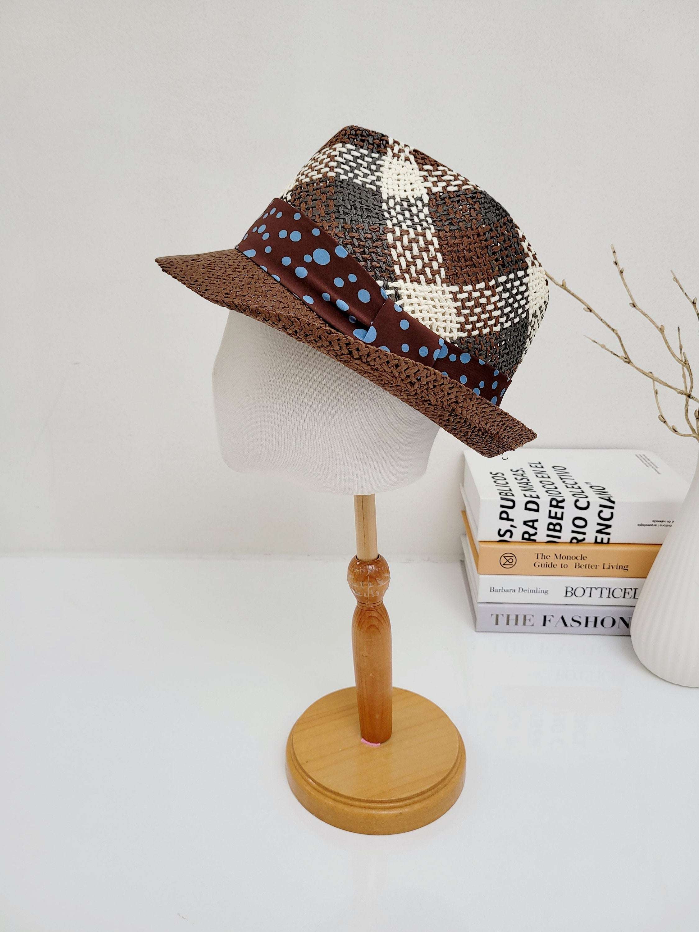 Breezy fedora: Brown & white plaid hat with a stylish blue polka dot band, displayed on a mannequin head.